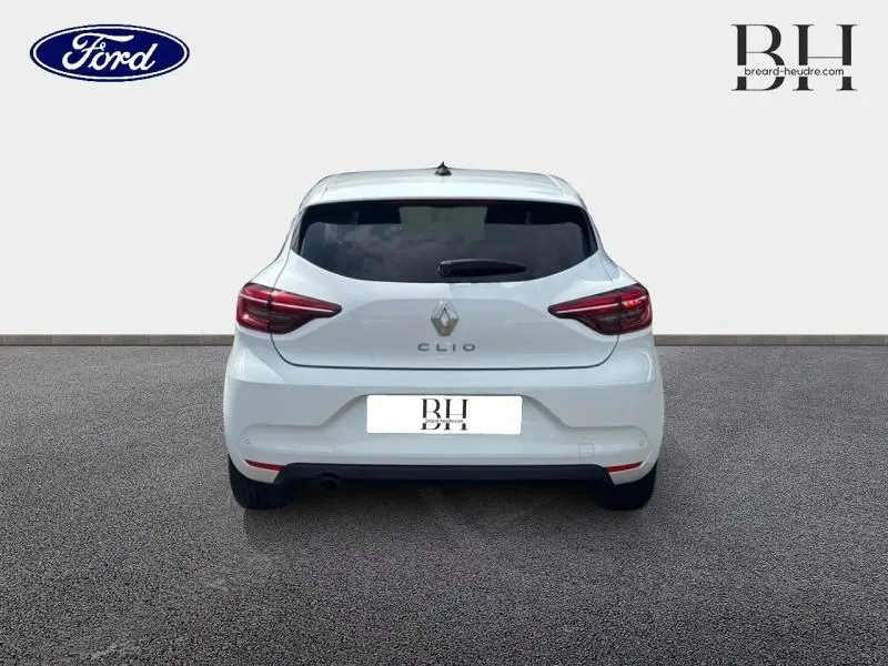 Vue arrière d'une Renault Clio blanche 2023 avec vitres arrière surteintées et feux arrière LED distinctifs.