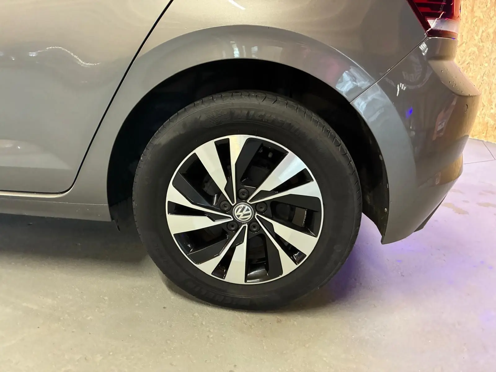 Gros plan sur la roue arrière droite grise d'une Volkswagen Polo 1.0 TSI 95 Confortline avec jante alliage bicolore.