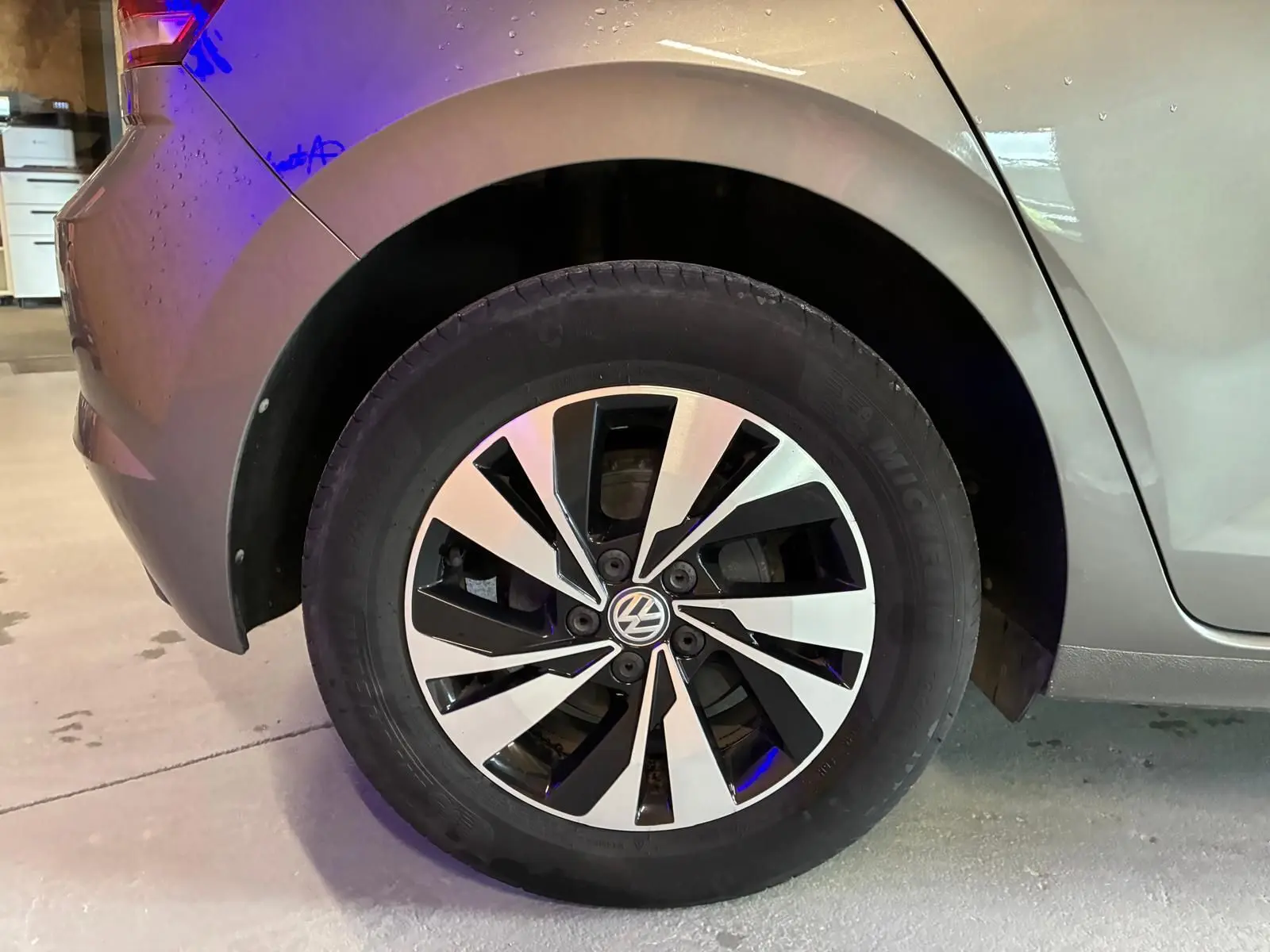 Gros plan sur la roue arrière droite d'une Volkswagen Polo gris métallisé de 2018 avec jante alliage bicolore.