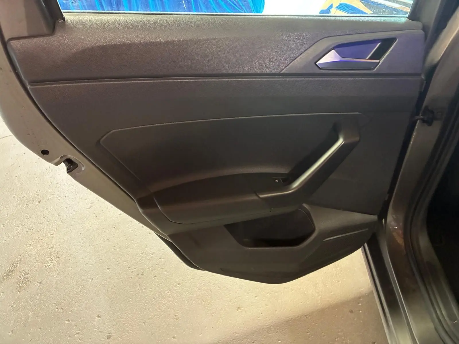 Vue rapprochée de la porte arrière droite noire intérieure d’une Volkswagen Polo 2018 gris métallisé.