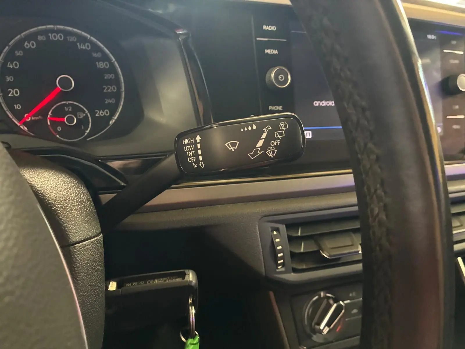 Vue intérieure du volant et du commodo d’essuie-glace d’une Volkswagen Polo gris 2018 avec tableau de bord et écran tactile.