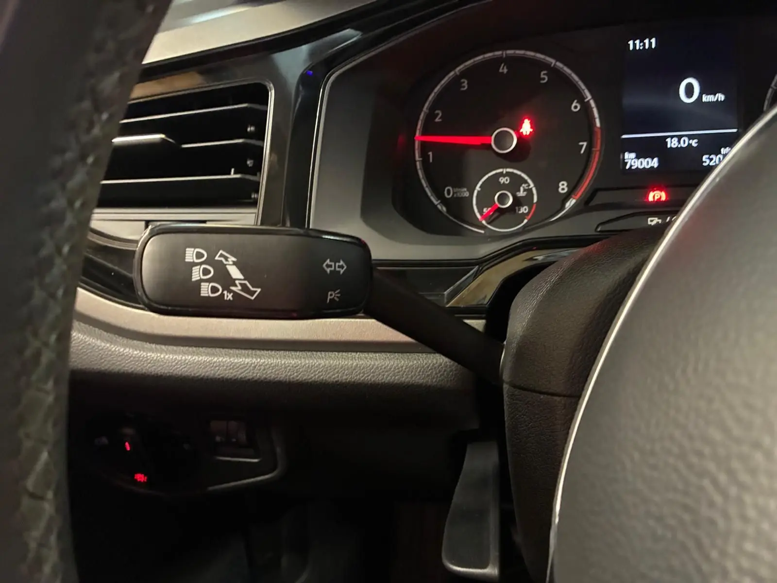Vue rapprochée du commodo gauche et du tableau de bord noir d'une Volkswagen Polo gris, affichant le compte-tours et l'écran digital.