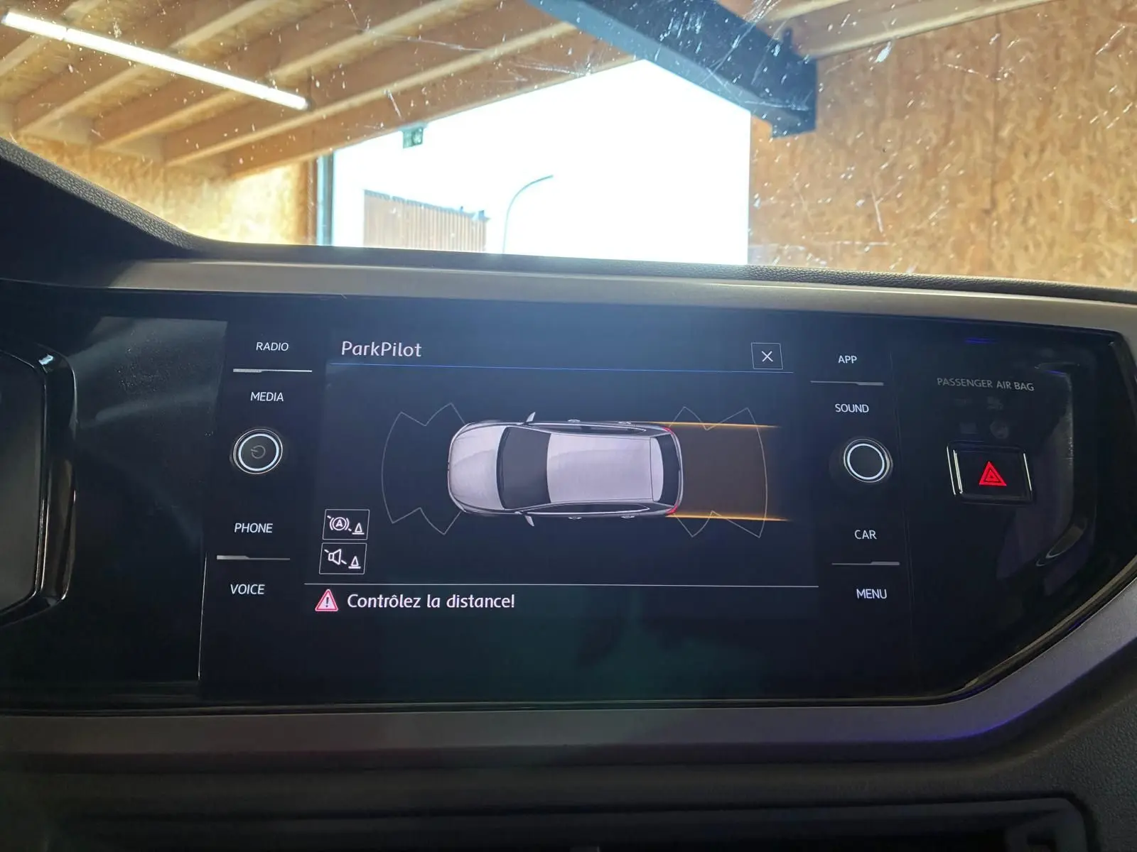 Écran central de la Volkswagen Polo gris 2018 montrant l'interface ParkPilot avec avertissement de distance.