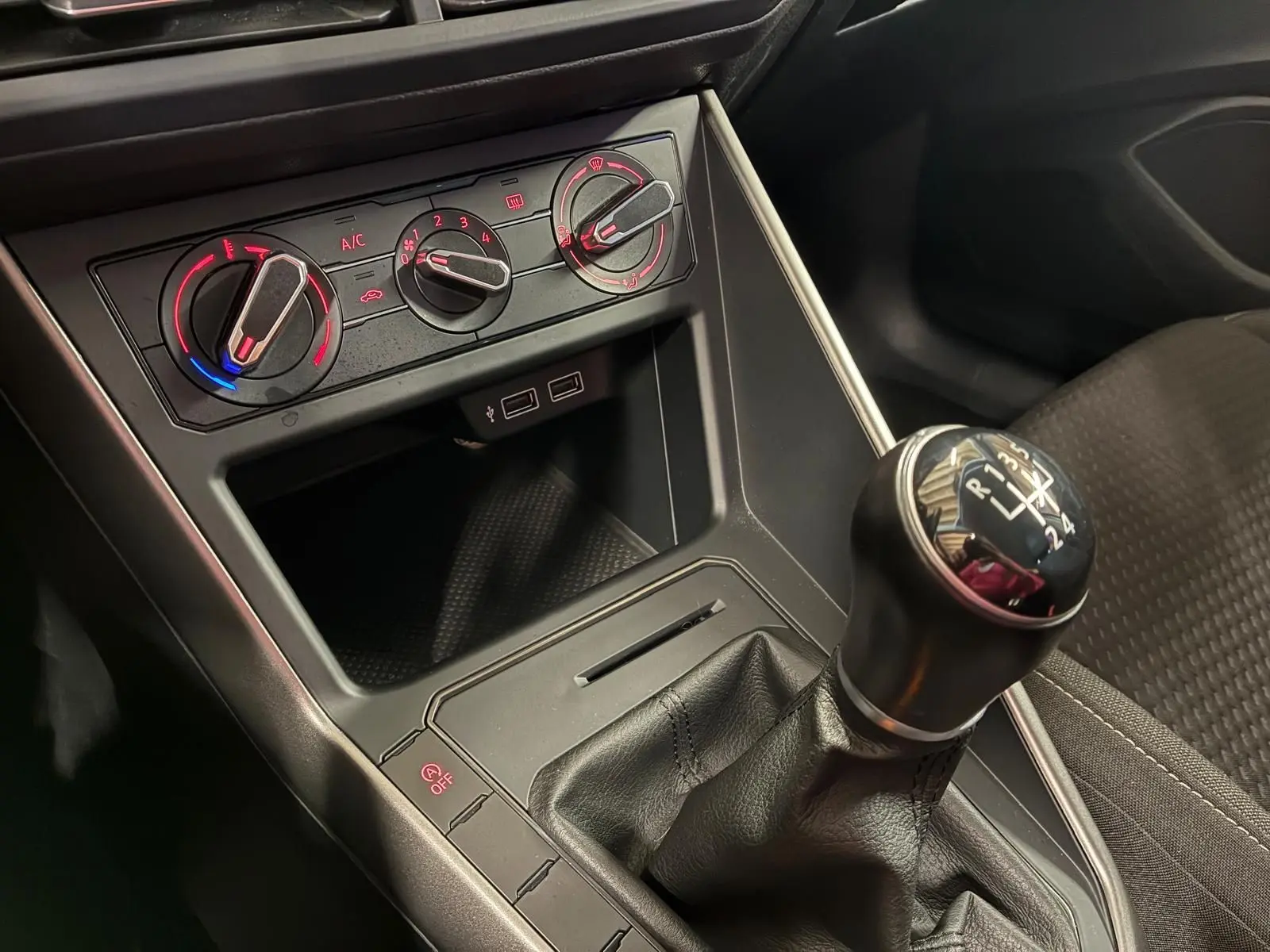Vue rapprochée de la console centrale d’une Volkswagen Polo 1.0 TSI 95 Confortline 2018, avec levier de vitesse manuel et commandes de climatisation.