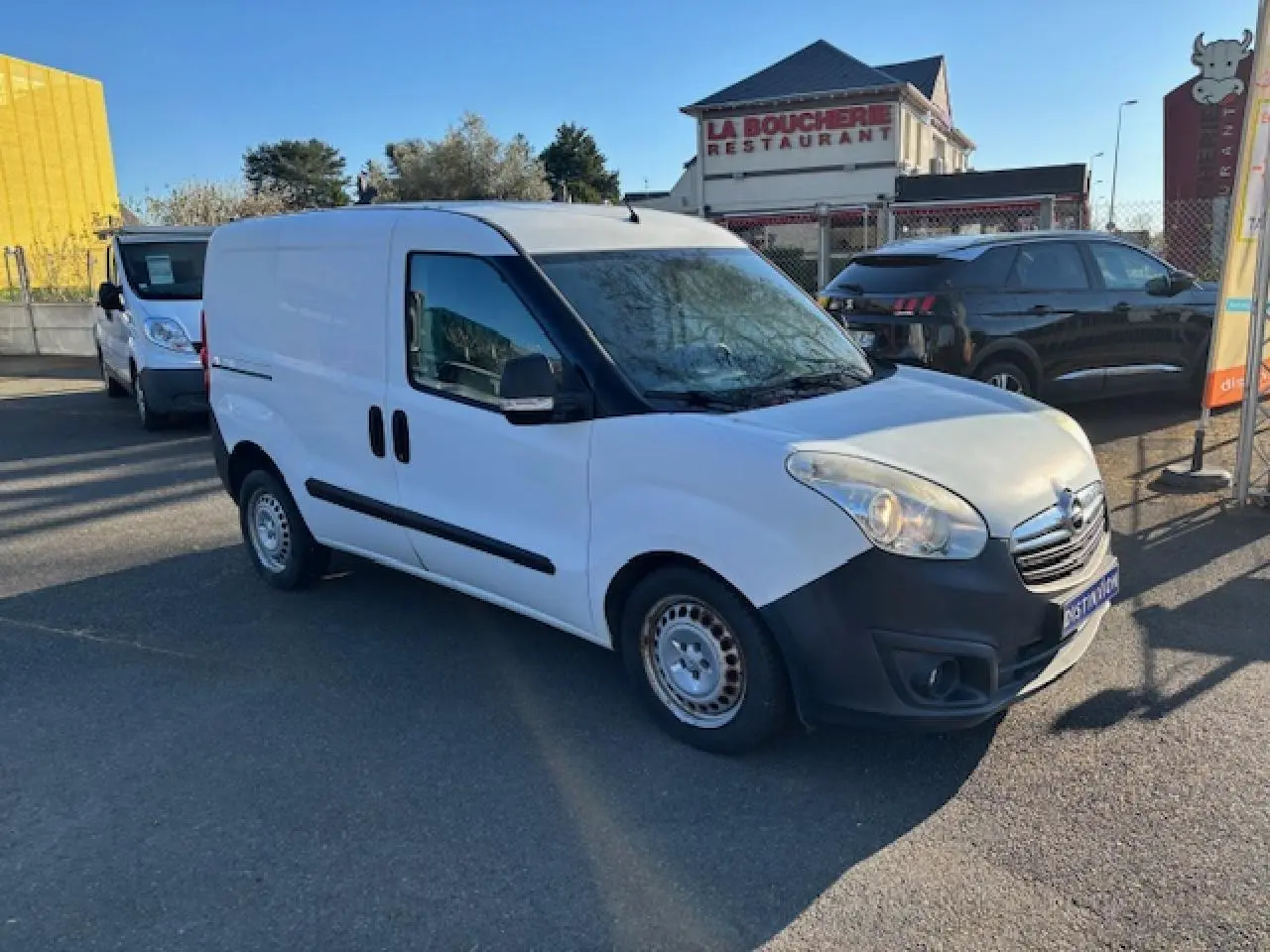 Vue 3/4 avant droite d’un Opel Combo blanc avec jantes tôle et pare-chocs noirs, stationné en extérieur.