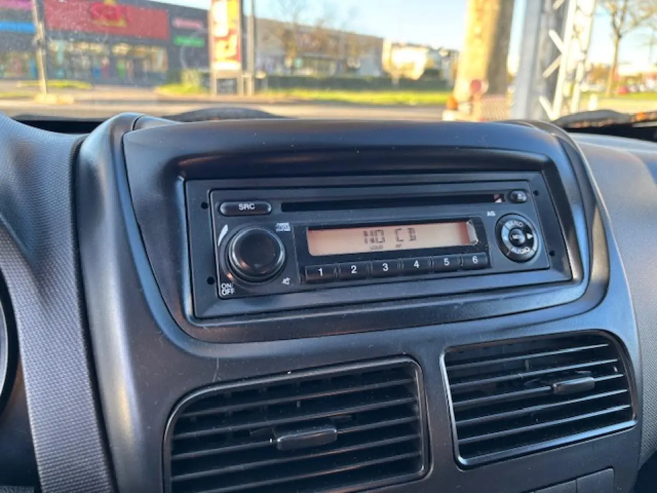 Gros plan sur la radio CD intégrée au tableau de bord noir de l’Opel Combo blanc, version L1H1 2015.