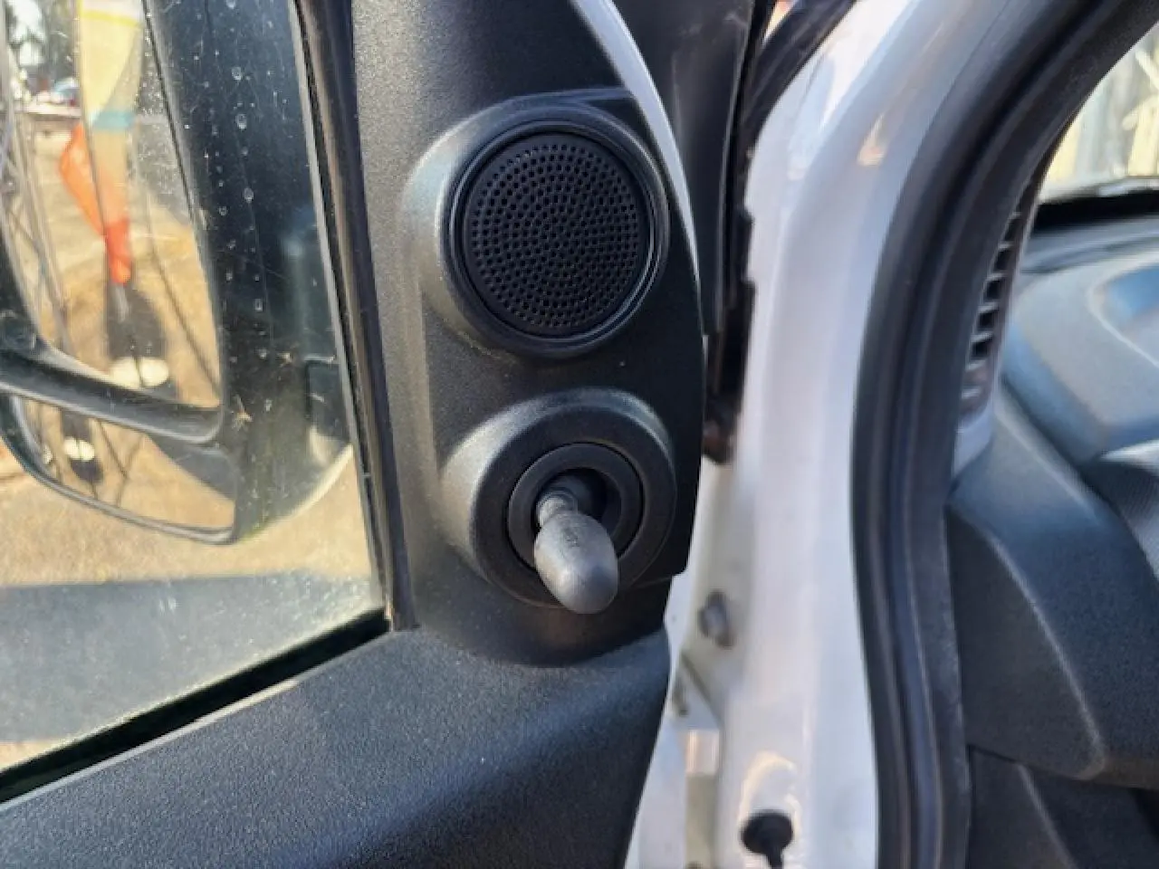 Détail du réglage manuel du rétroviseur côté conducteur sur Opel Combo blanc L1H1 2015, intérieur visible.