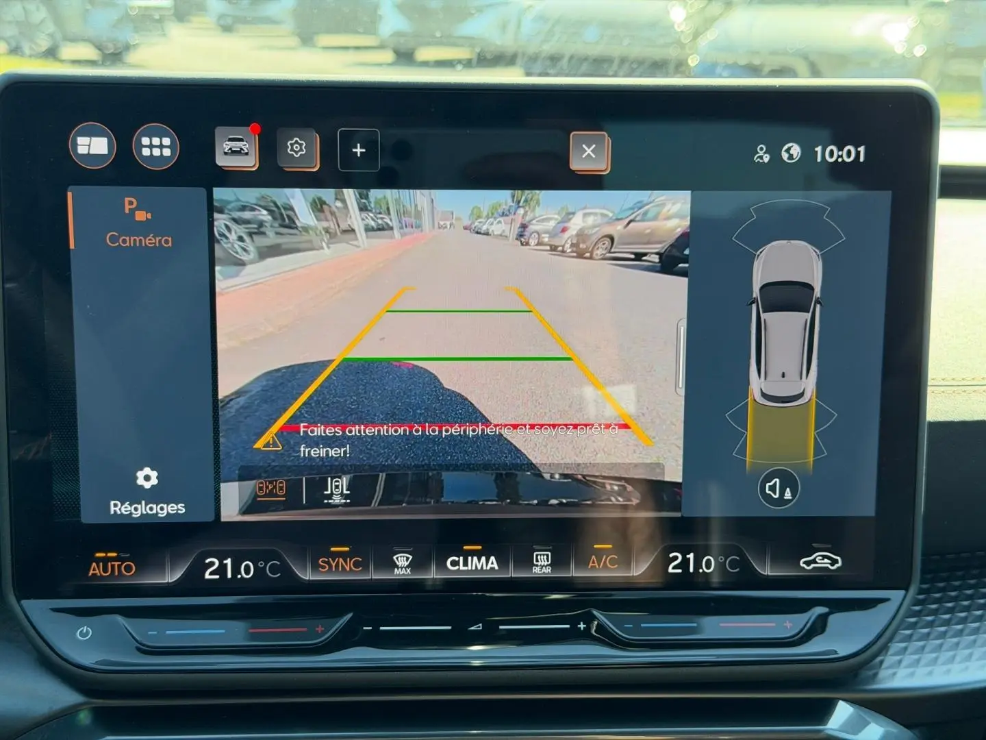 Écran tactile intérieur montrant la caméra de recul active avec vue arrière et alertes de proximité du CUPRA Formentor gris métallisé.