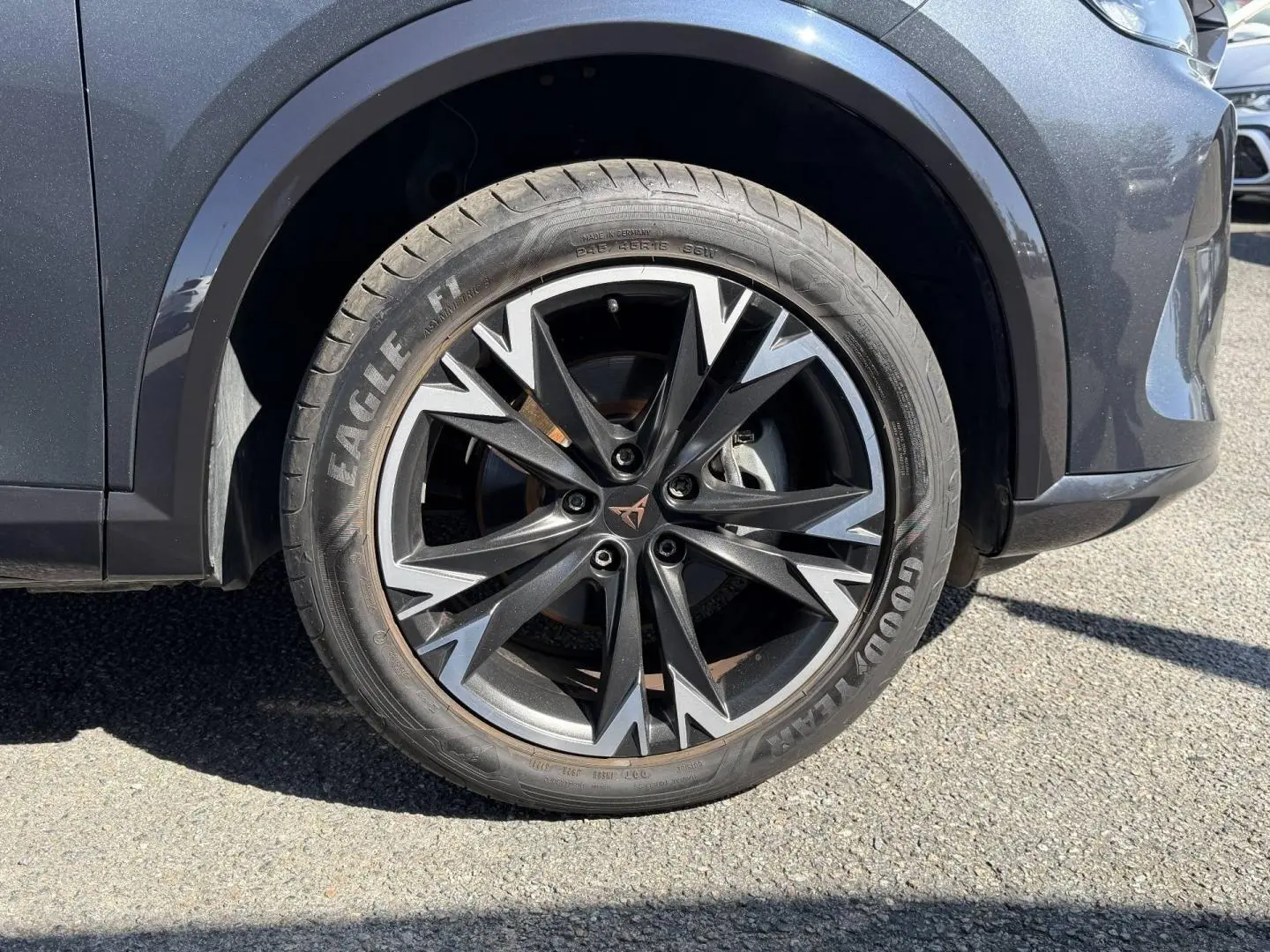 Gros plan sur la roue avant droite du CUPRA Formentor gris Magnétique, jante alu noire et argentée au design sportif.