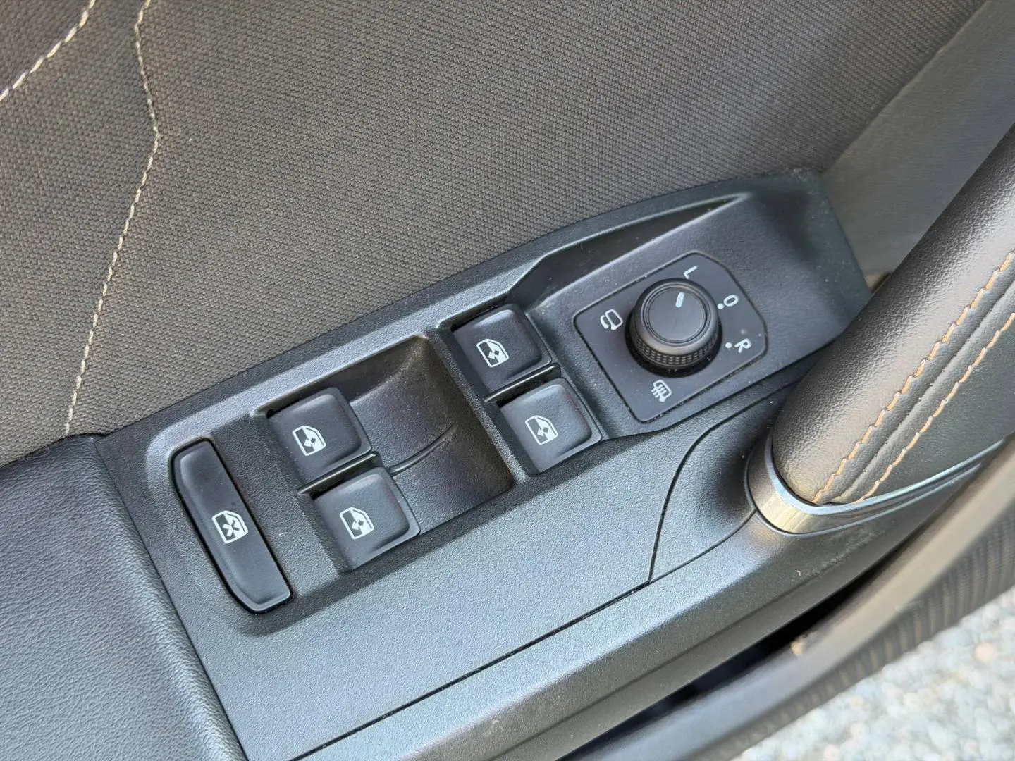 Gros plan sur les commandes des vitres et rétroviseurs côté conducteur d’une CUPRA Formentor gris Magnétique.