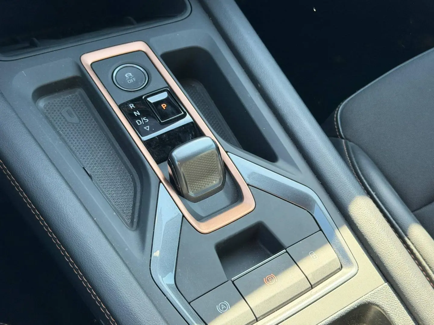 Vue rapprochée de la console centrale noire avec levier de vitesse automatique et surpiqûres cuivre du CUPRA Formentor 2025.