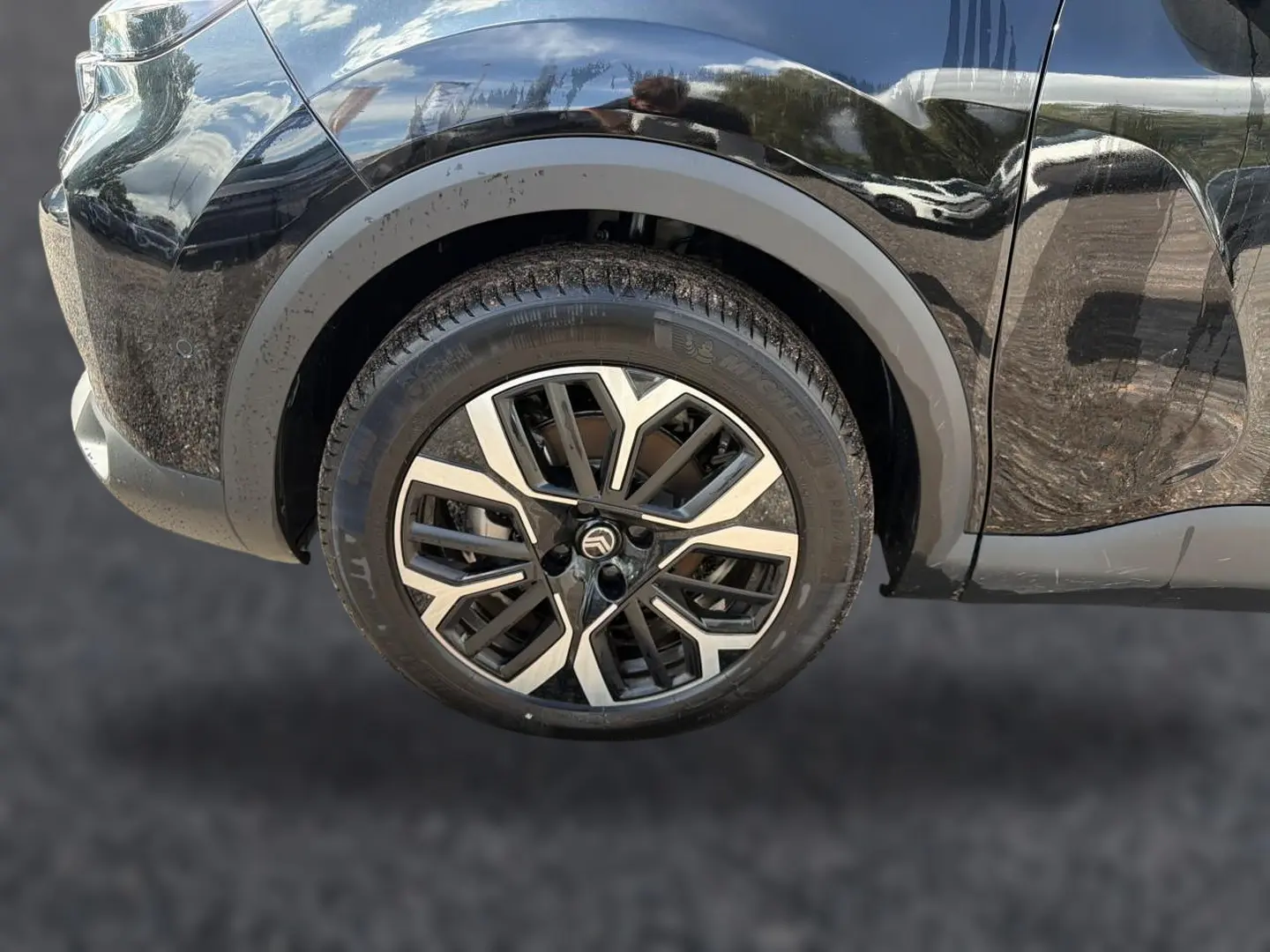 Gros plan sur la roue avant gauche noire d'une Citroën C4 X 2025 avec jante alu au design moderne.