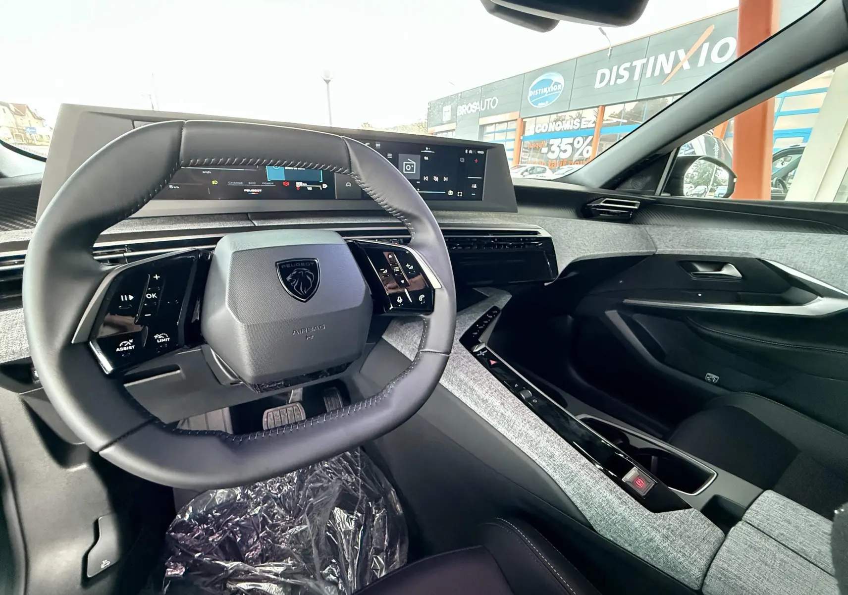 Intérieur du Peugeot 3008 Hybrid 2025 vu côté conducteur, volant compact et tableau de bord numérique moderne.