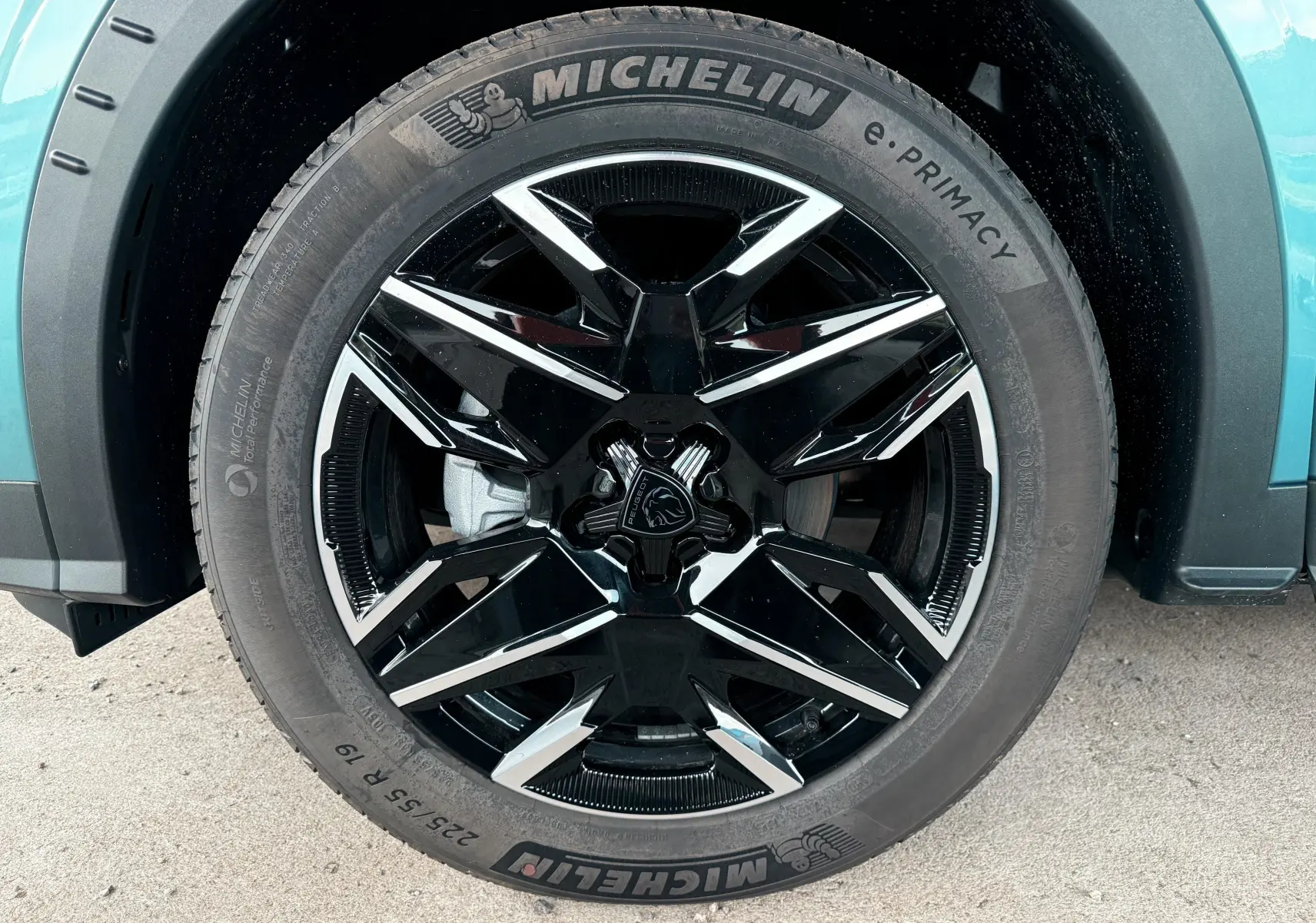 Gros plan sur la roue avant droite du Peugeot 3008 Hybrid 2025 bleu Ingaro Metal avec jante noire et argentée distinctive.