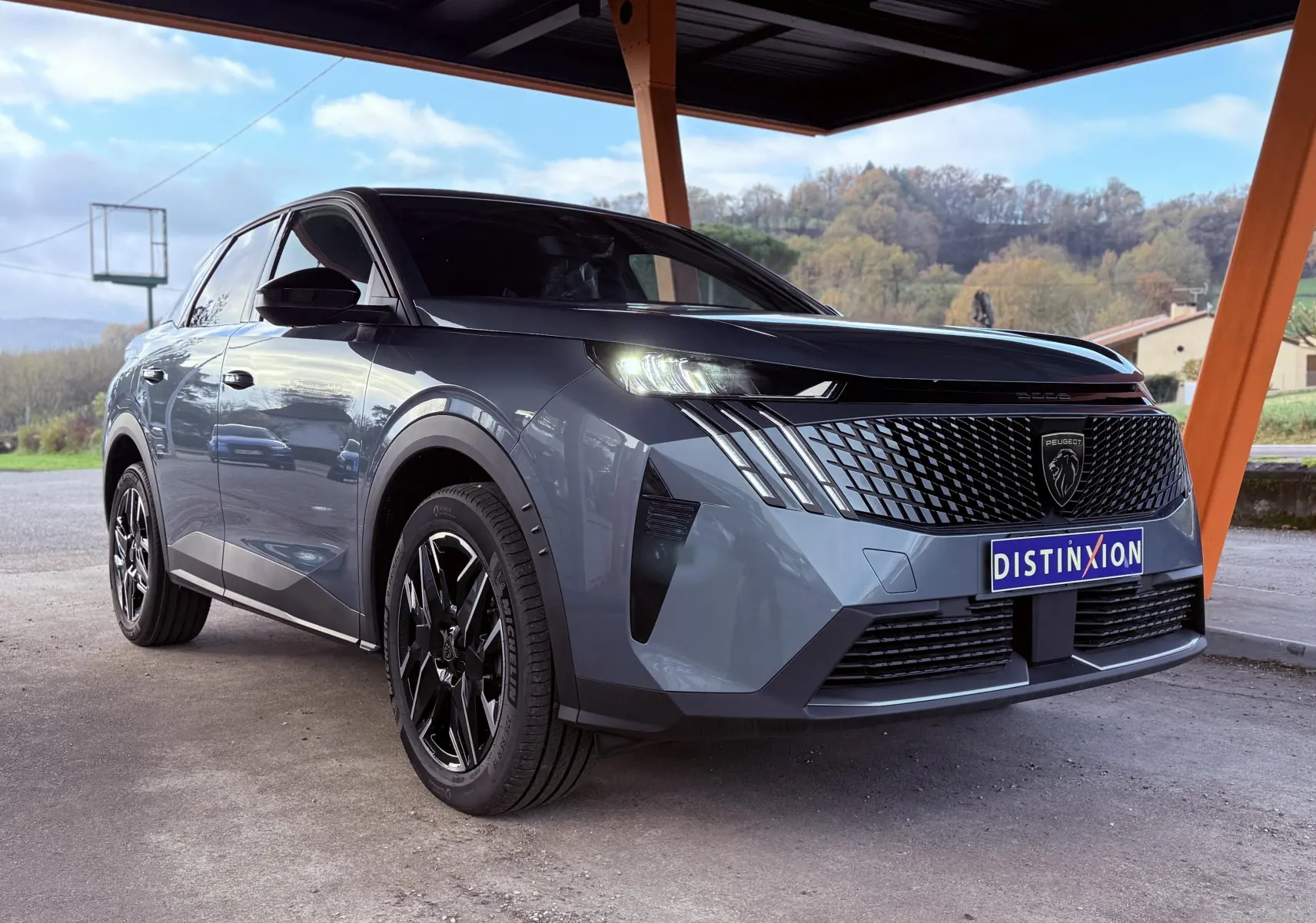 Peugeot 3008 Hybrid 2025 bleu Ingaro métal en 3/4 avant droit, avec calandre noire et feux LED distinctifs allumés.