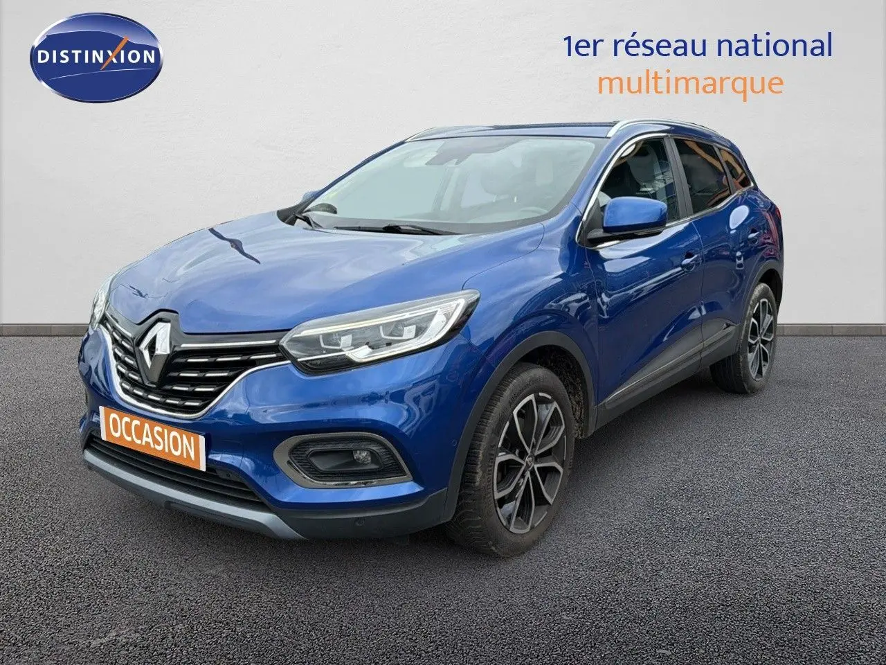 Renault Kadjar Bleu Iron en 3/4 avant droit, SUV compact avec jantes alliage bicolores et calandre noire distinctive.