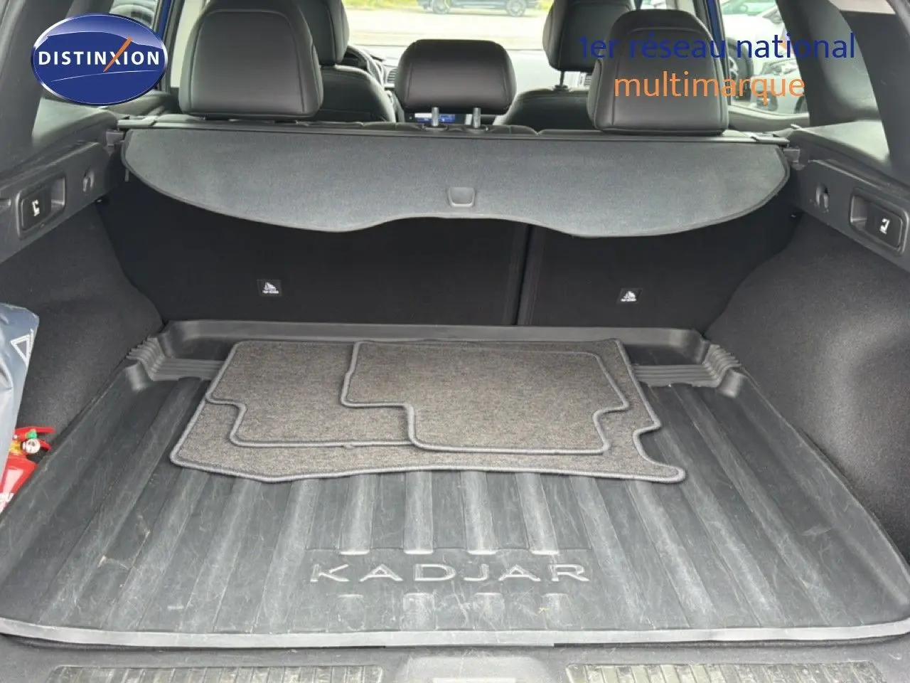 Coffre ouvert d’un Renault Kadjar 1.5 Blue dCi 115ch Intens 2021, tapis de sol et cache-bagages visibles.