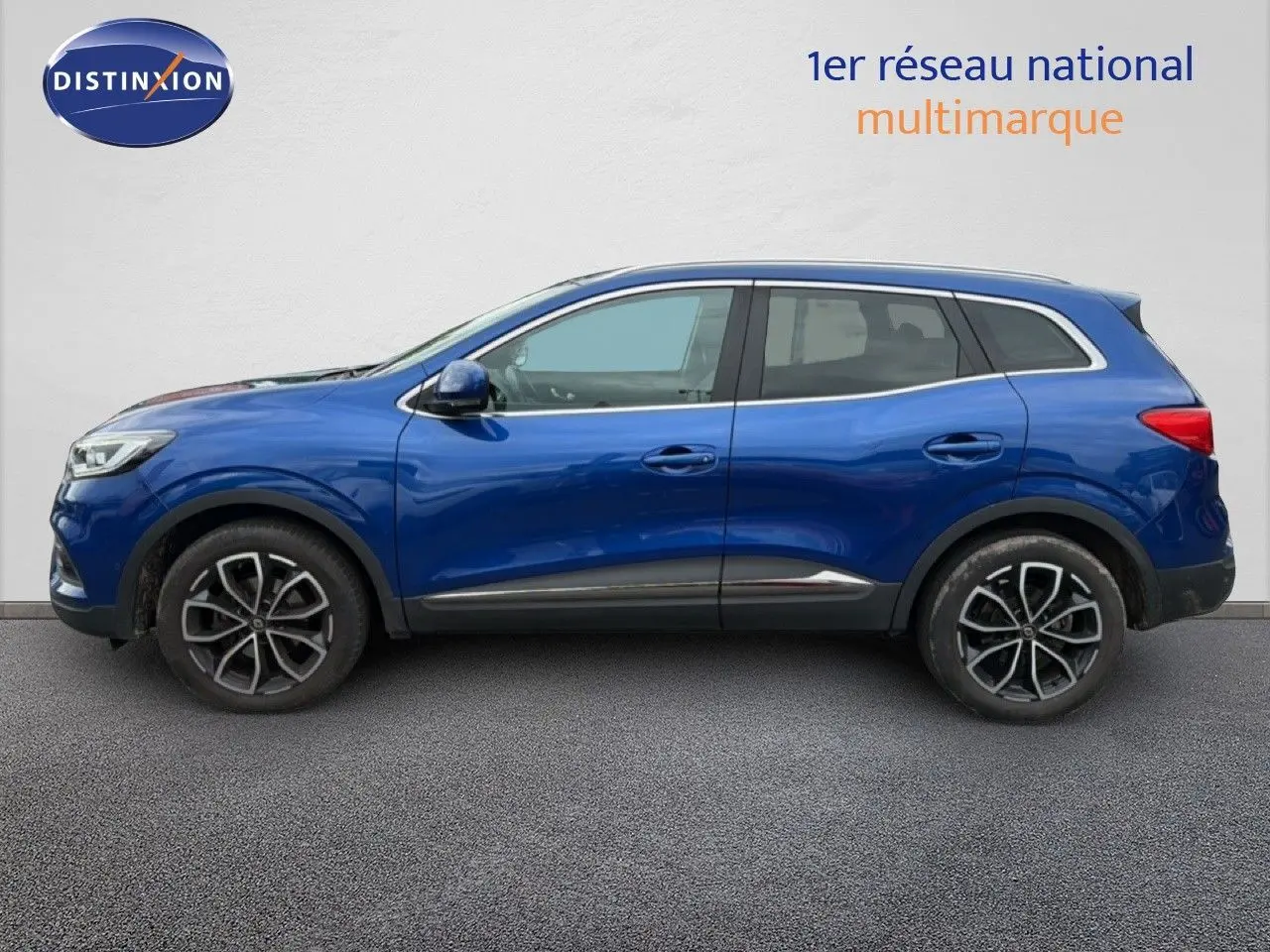 Profil côté gauche d'un Renault Kadjar 2021 bleu Iron avec jantes alliage noires et détails chromés.