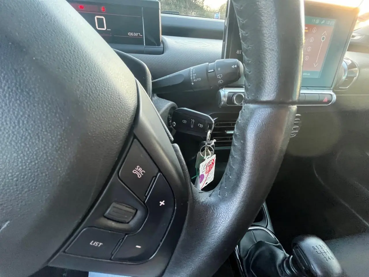 Gros plan sur le volant noir de la Citroën C4 Cactus 2020 avec commandes au volant et levier de vitesse manuel visible.