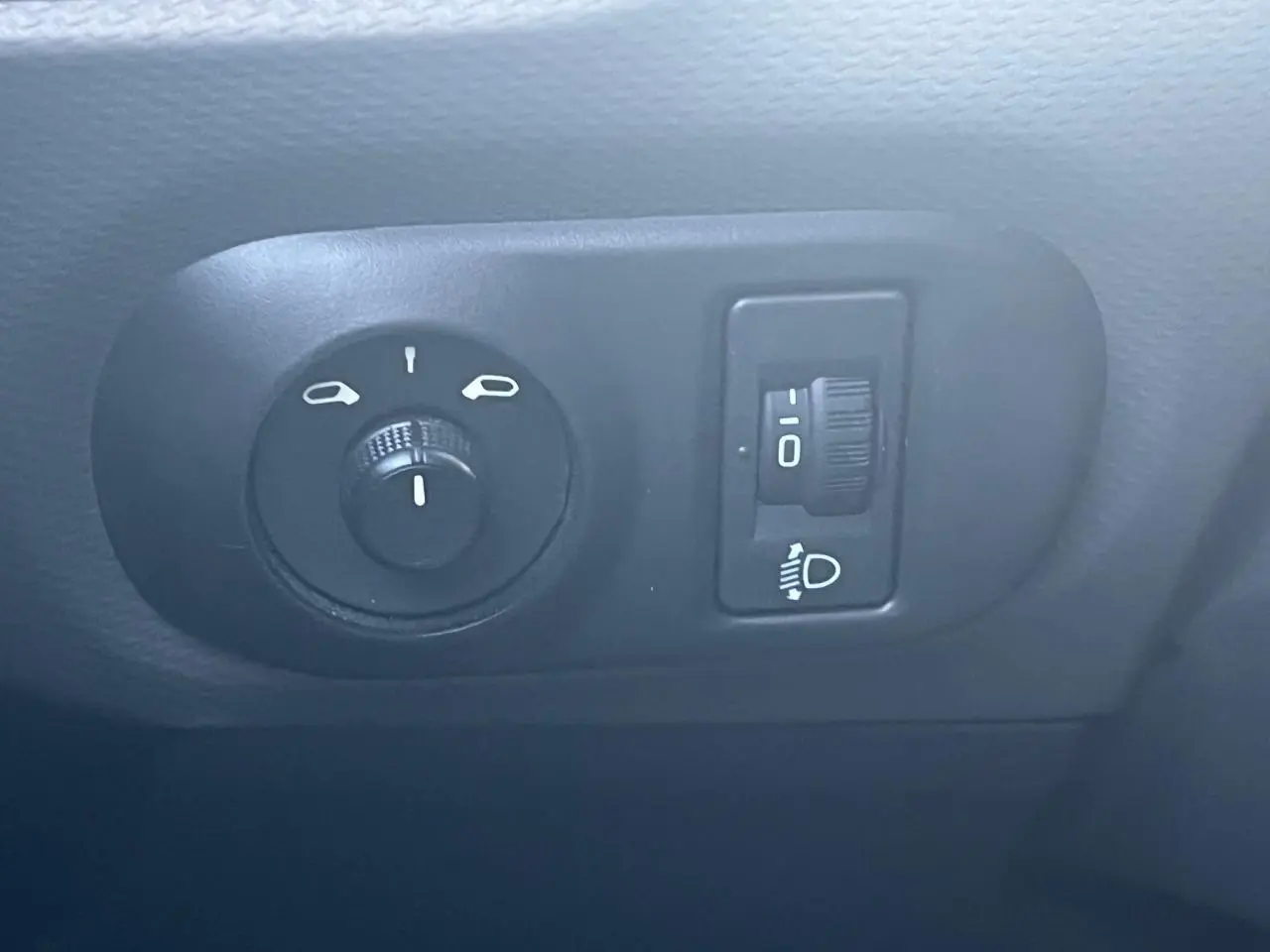Détail des commandes d’éclairage et réglage des phares dans l’habitacle d’une Citroën C4 Cactus blanche, version 2020.