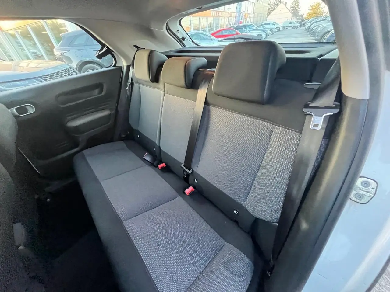 Vue intérieure côté arrière droit montrant la banquette arrière grise du Citroën C4 Cactus blanc de 2020.