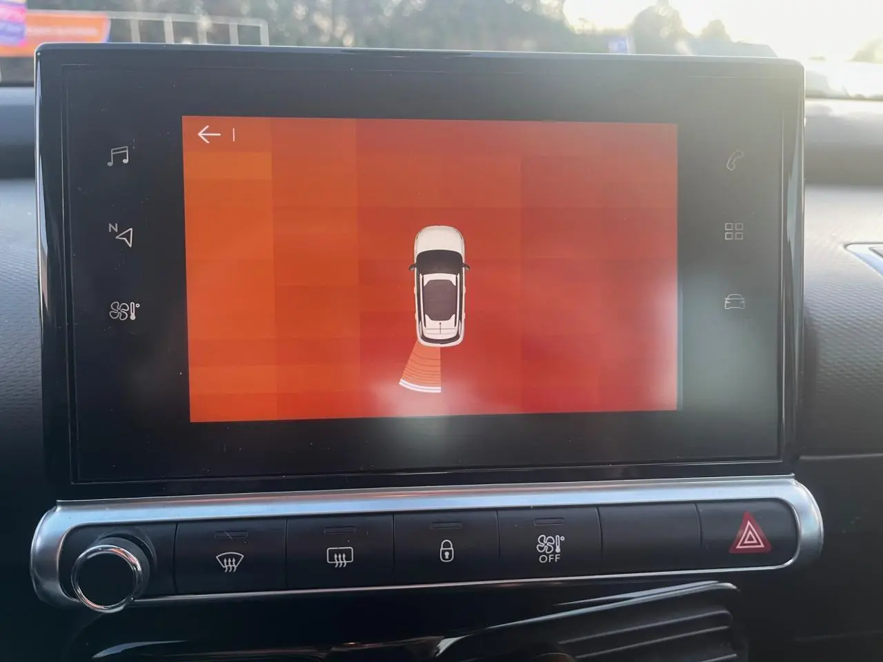 Écran tactile central du Citroën C4 Cactus 2020 montrant l'aide au stationnement avec vue schématique du véhicule blanc.