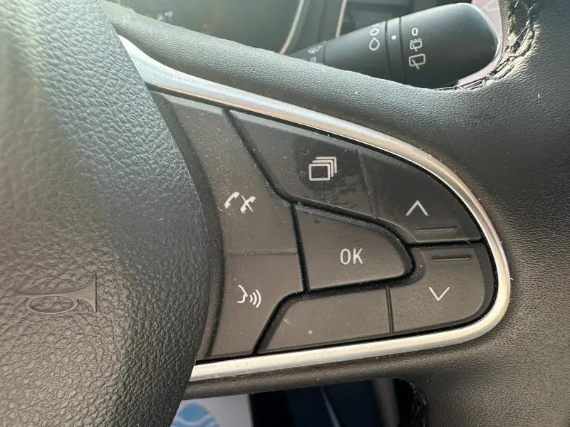 Gros plan sur les commandes multifonctions noires du volant de la Renault Mégane Break gris Titanium 2024.