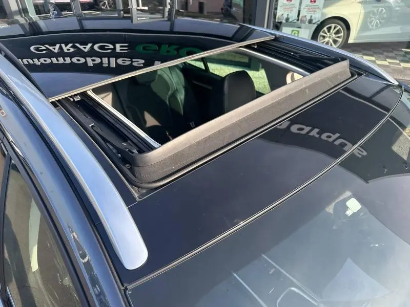 Toit ouvrant panoramique ouvert sur Renault Mégane Break gris titanium, vue plongeante sur l'avant du véhicule.