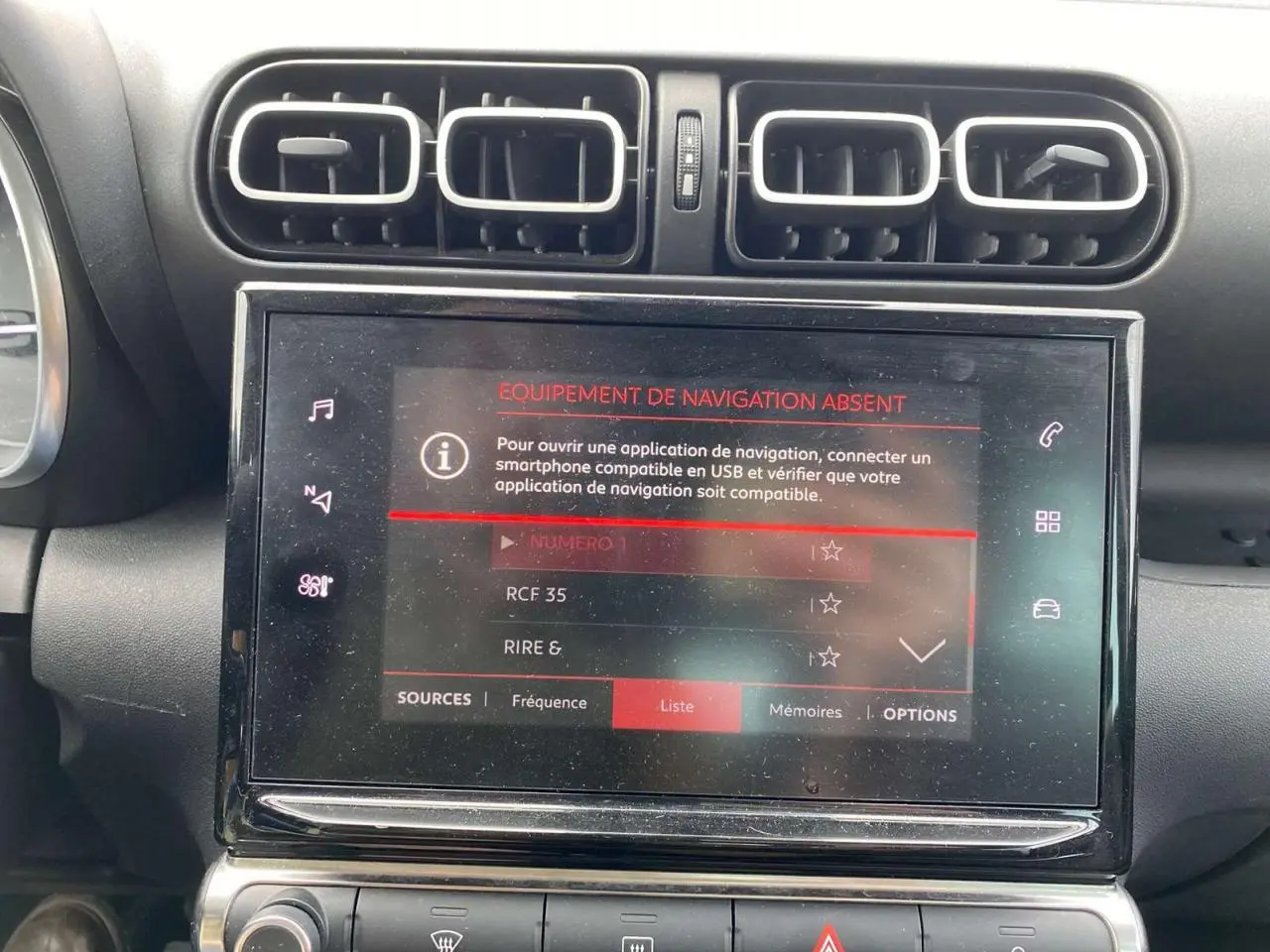 Vue rapprochée de la console centrale du Citroën C3 Aircross blanc 2023, écran tactile avec message d'absence de navigation.