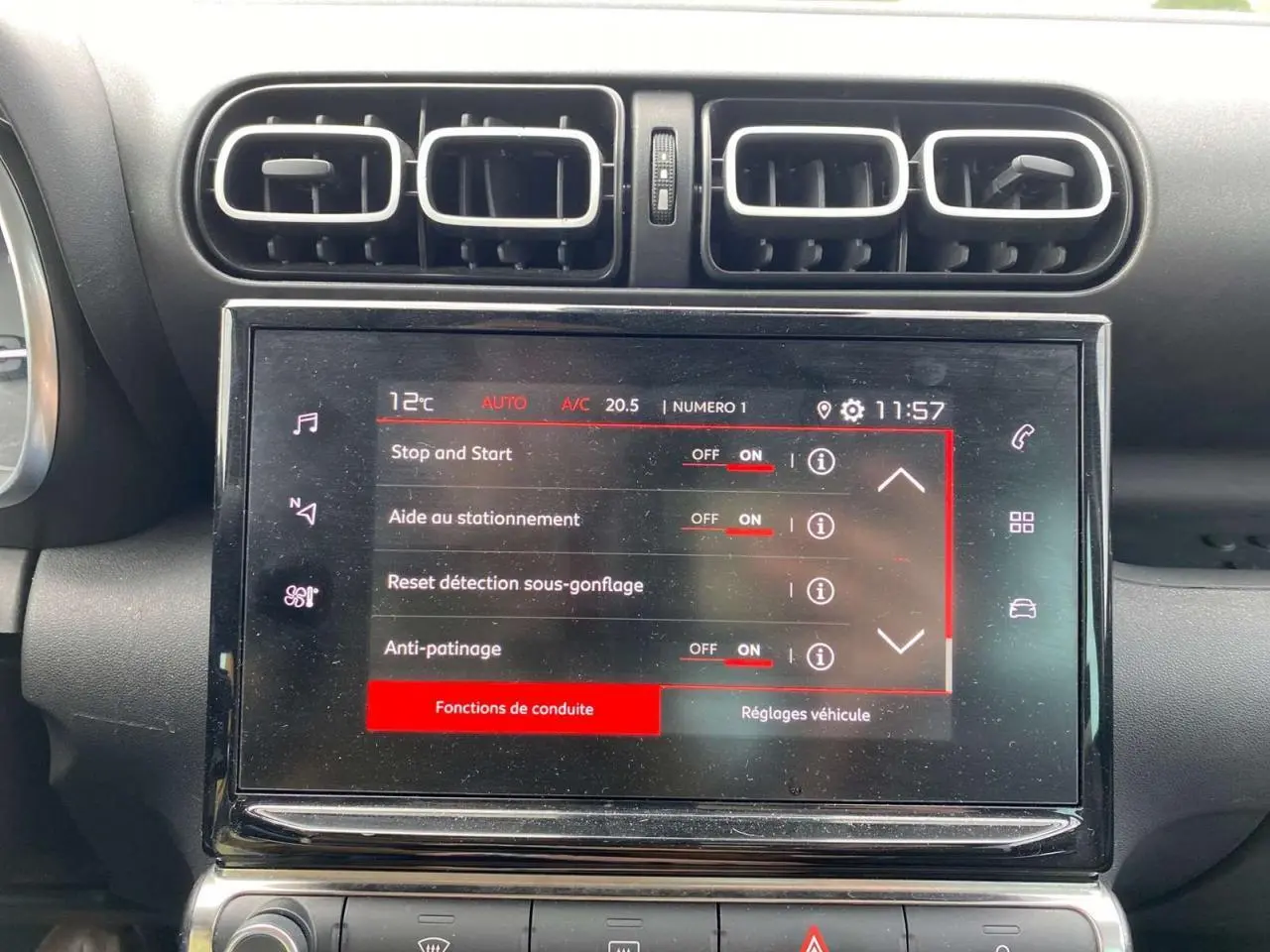 Vue rapprochée de l’écran tactile central du Citroën C3 Aircross 2023 blanc, affichant les réglages de conduite.