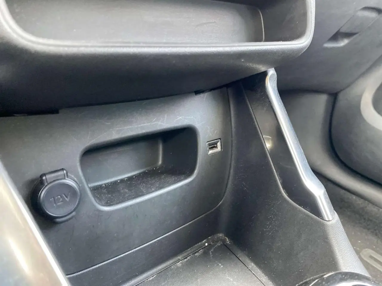 Détail de la console centrale côté passager du Citroën C3 Aircross blanc 2023 avec prise 12V et port USB visible.