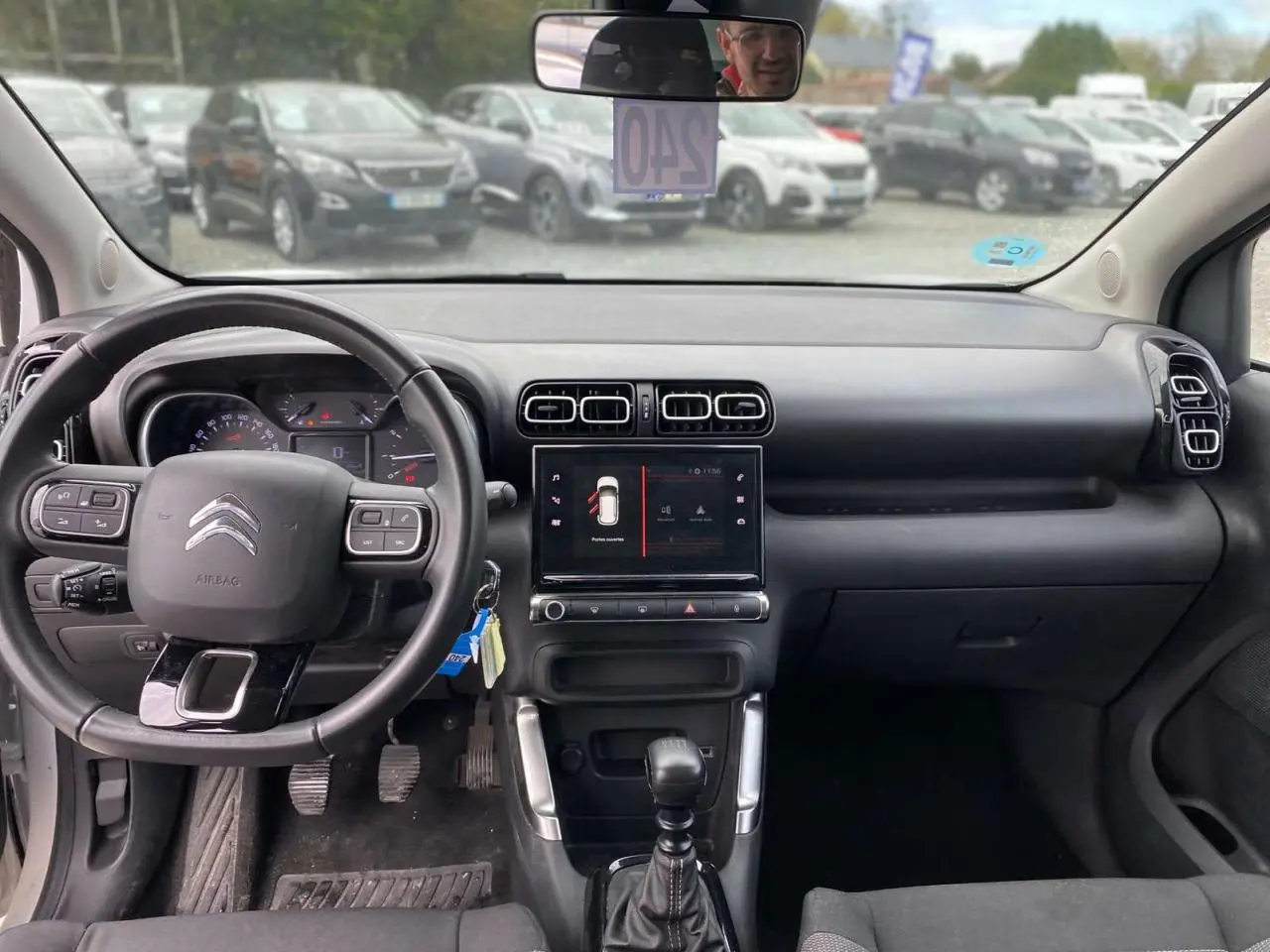 Vue intérieure du tableau de bord et volant du Citroën C3 Aircross blanc 2023, version diesel manuelle Shine.