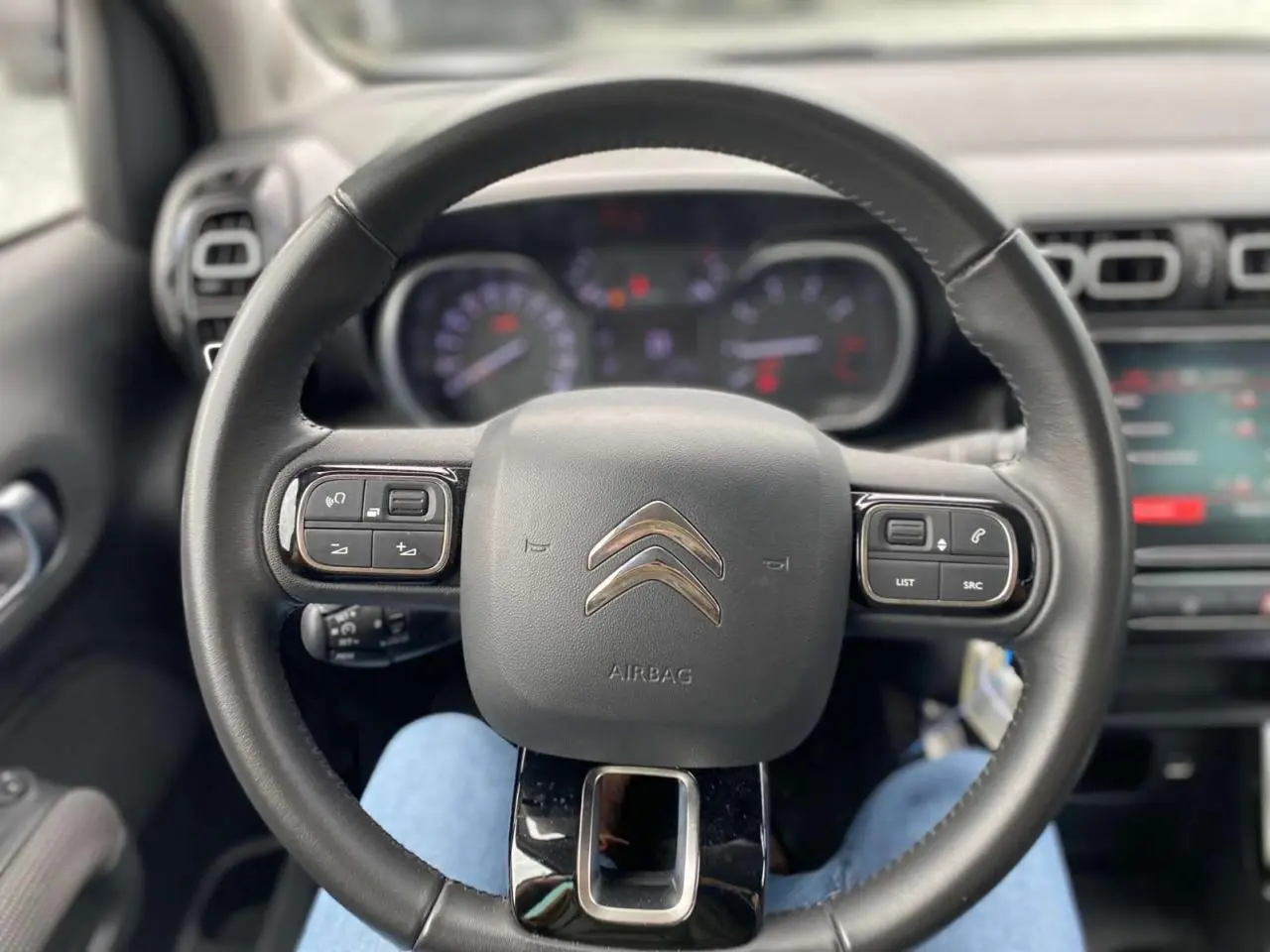 Vue centrée du volant noir avec commandes intégrées du Citroën C3 Aircross 2023, version Shine diesel.