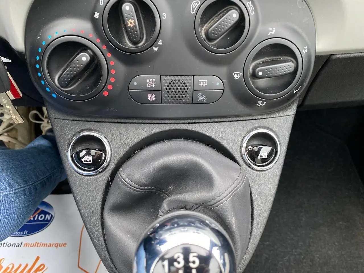 Gros plan intérieur sur la console centrale de la Fiat 500 2019, montrant la commande de climatisation et le levier de vitesses manuel.
