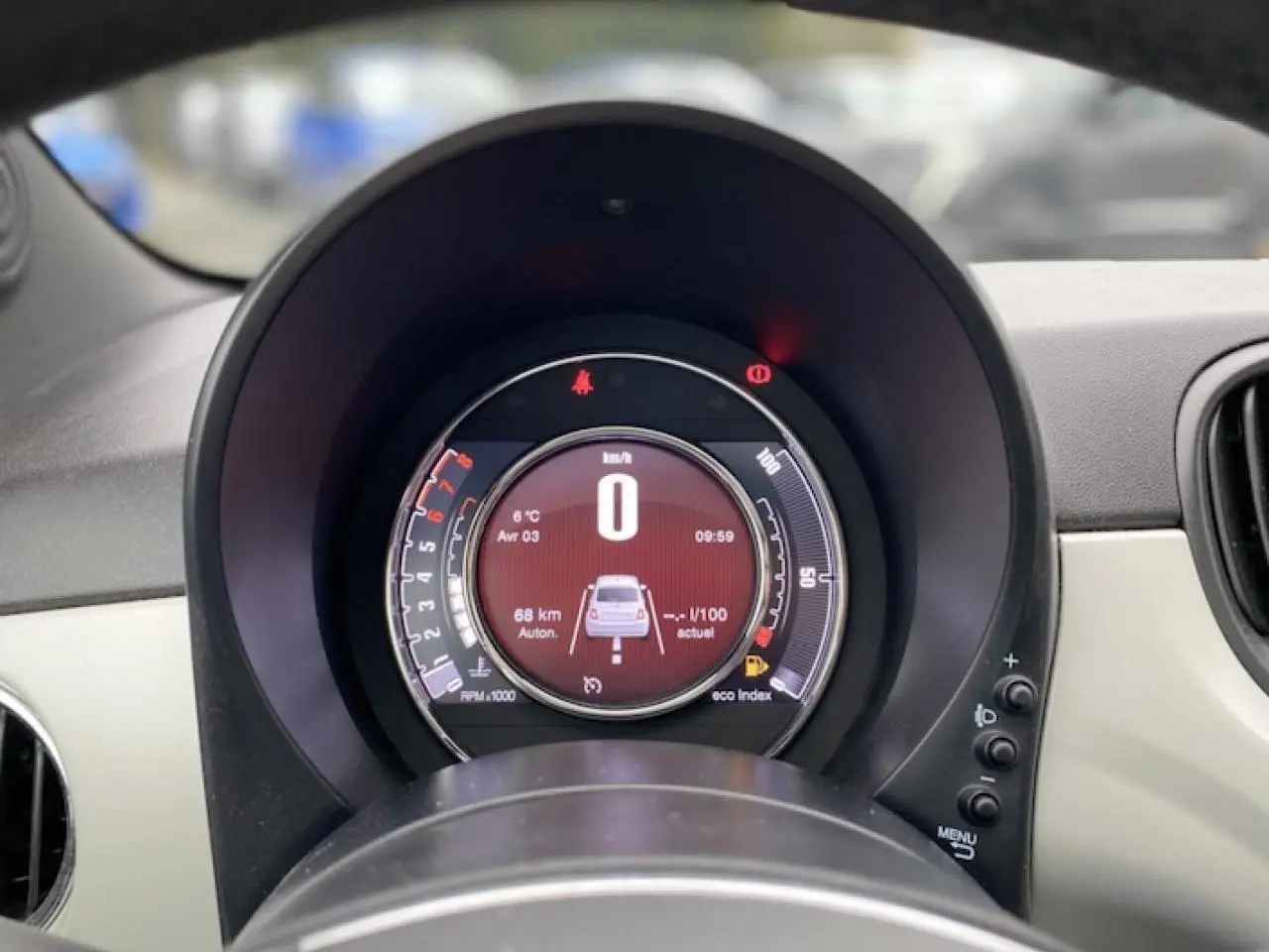 Vue rapprochée du tableau de bord numérique de la Fiat 500 2019, affichant la vitesse à zéro et l'autonomie restante.
