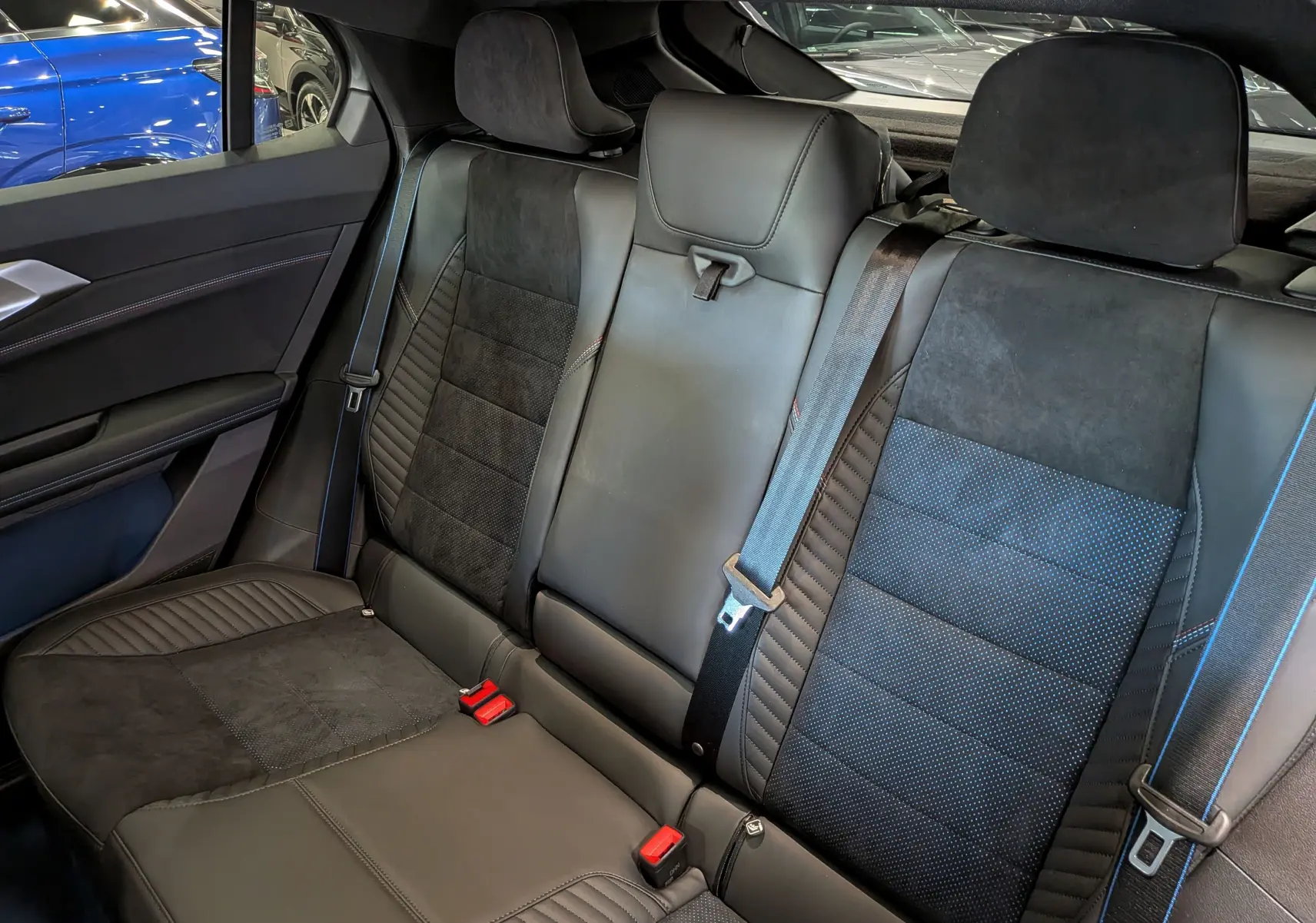 Vue intérieure des sièges arrière en cuir noir et alcantara avec surpiqûres bleues du Renault Rafale hyper hybrid 2026.