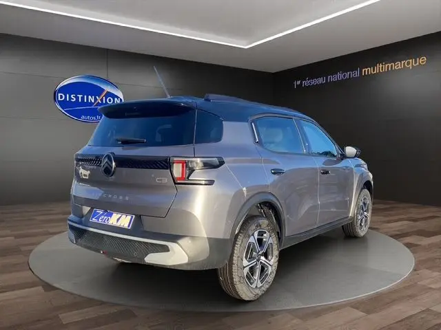 Vue 3/4 arrière droite du Citroën C3 Aircross gris Mercury avec toit noir, mettant en valeur ses feux arrière et jantes distinctives.