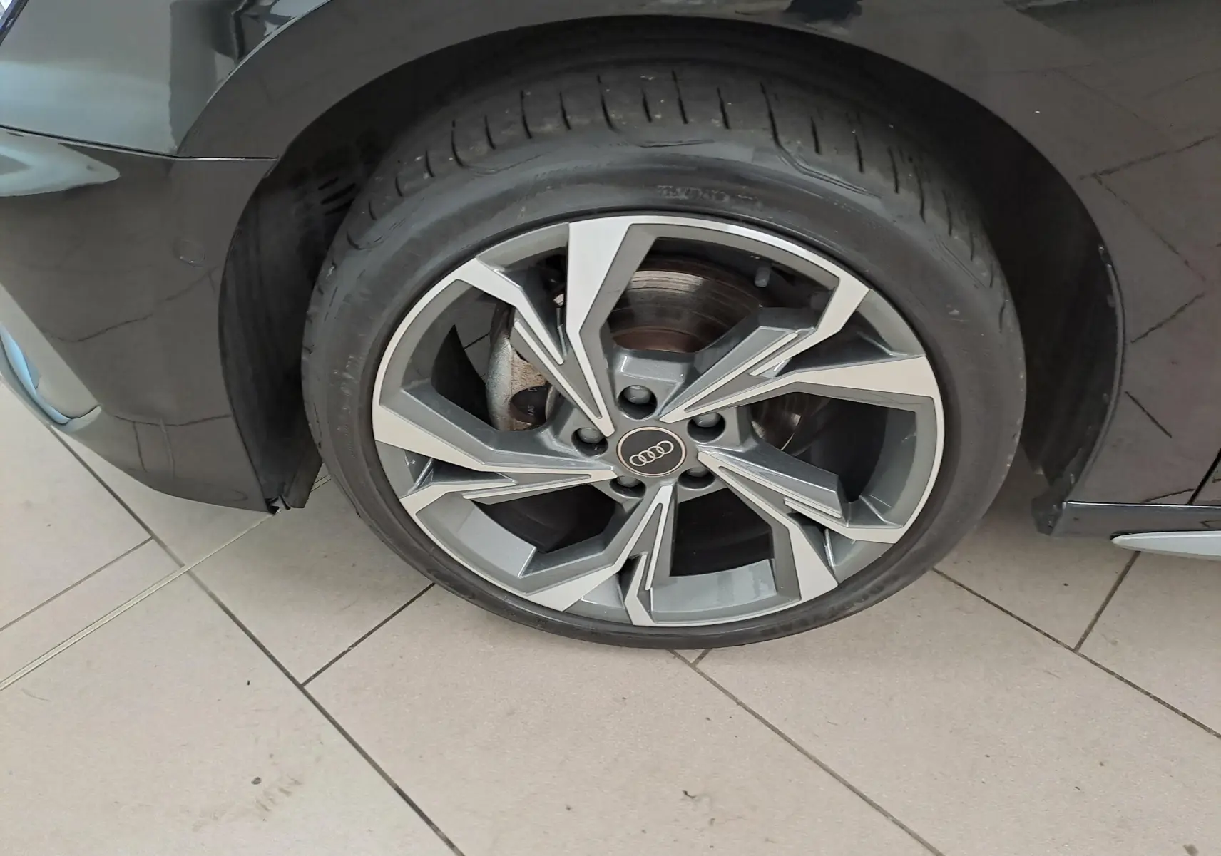 Gros plan sur la roue avant gauche de l’Audi A3 Sportback Noir Mythic avec jante alliage S Line 2023.