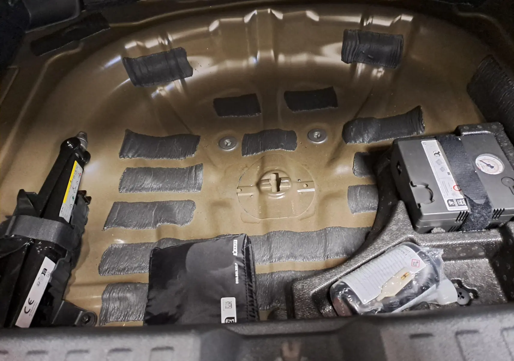 Vue rapprochée de la zone de rangement sous le coffre de l'Audi A3 Sportback 35 TFSI 150 S Line 2023, sans roue de secours.