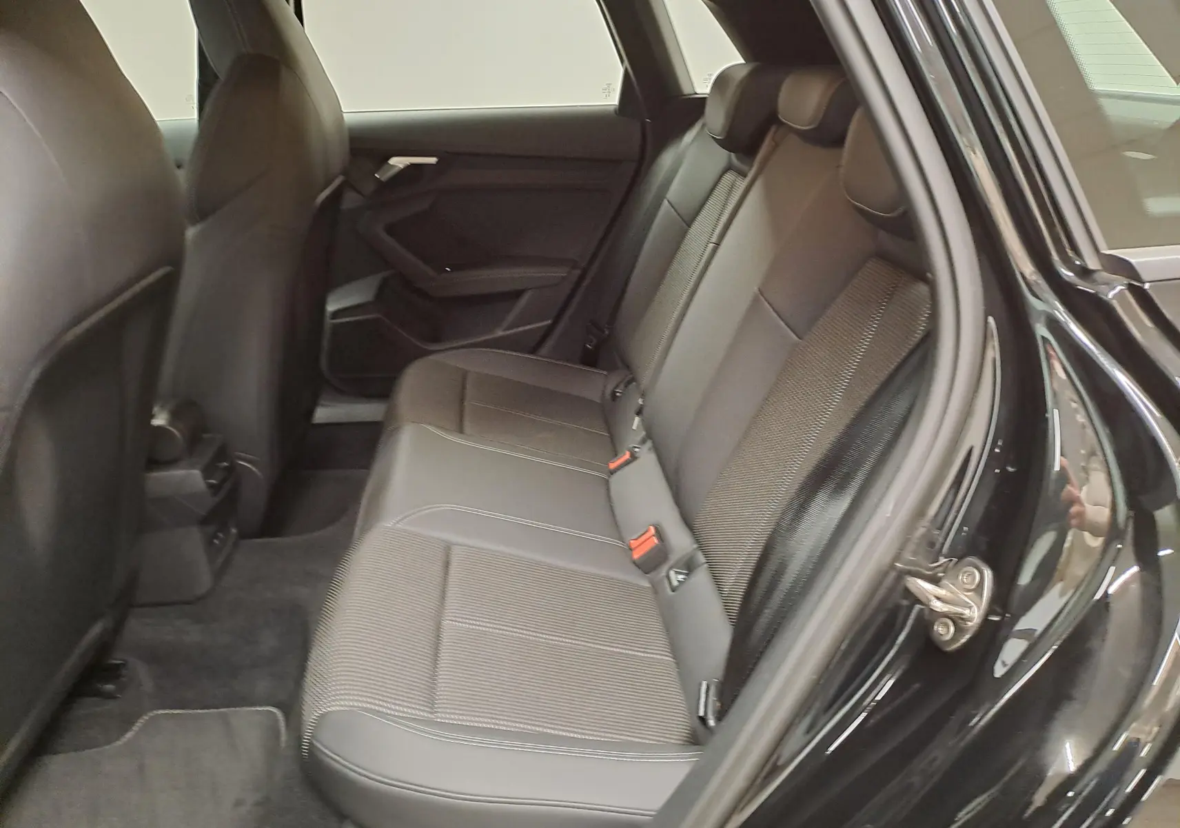 Vue intérieure côté droit des sièges arrière en tissu et cuir noir d’un Audi A3 Sportback 35 TFSI S Line 2023 Noir Mythic.