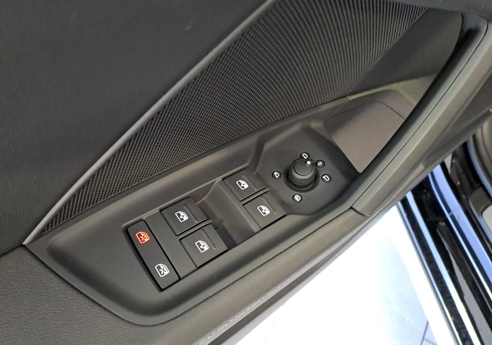 Gros plan sur les commandes de lève-vitres et réglage des rétroviseurs côté conducteur de l'Audi A3 Sportback Noir Mythic 2023.