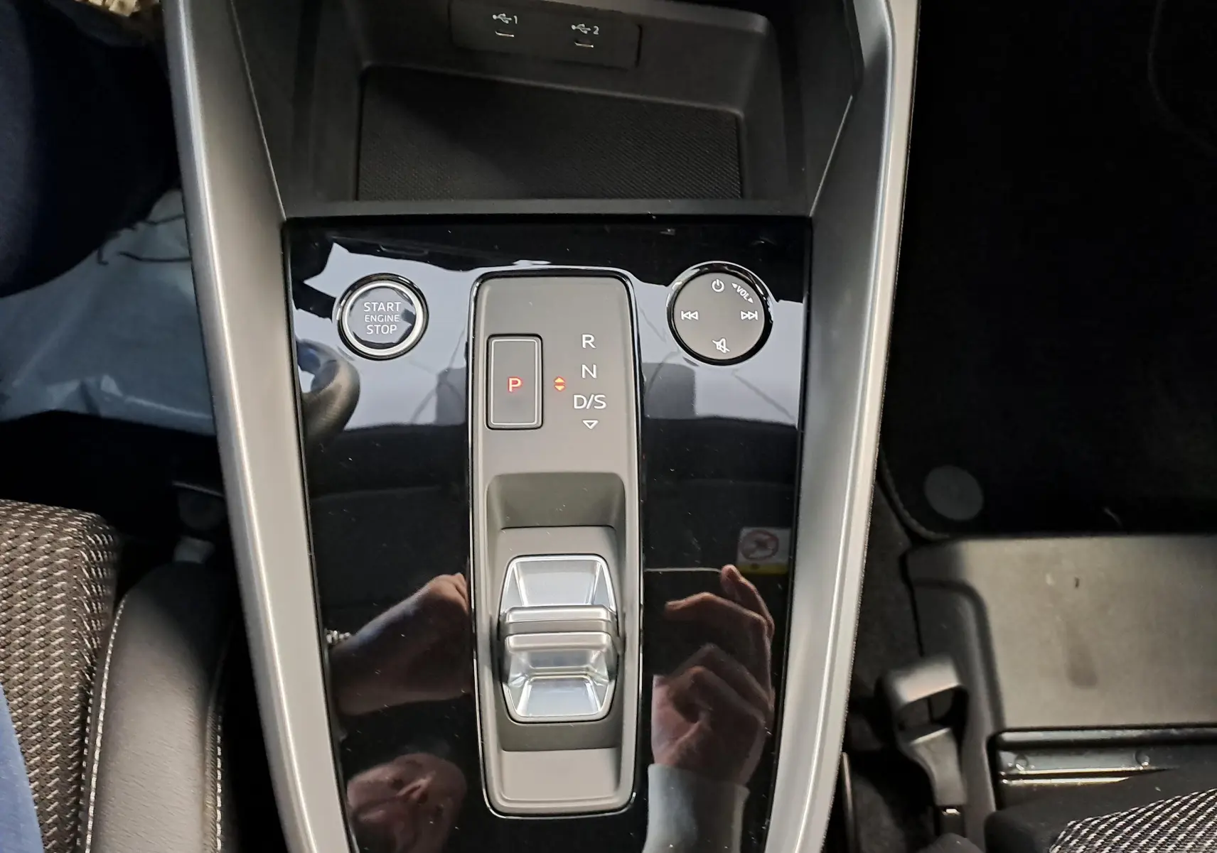 Vue plongeante sur la console centrale noire brillante de l’Audi A3 Sportback 35 TFSI S Line avec levier de vitesses et bouton start/stop.