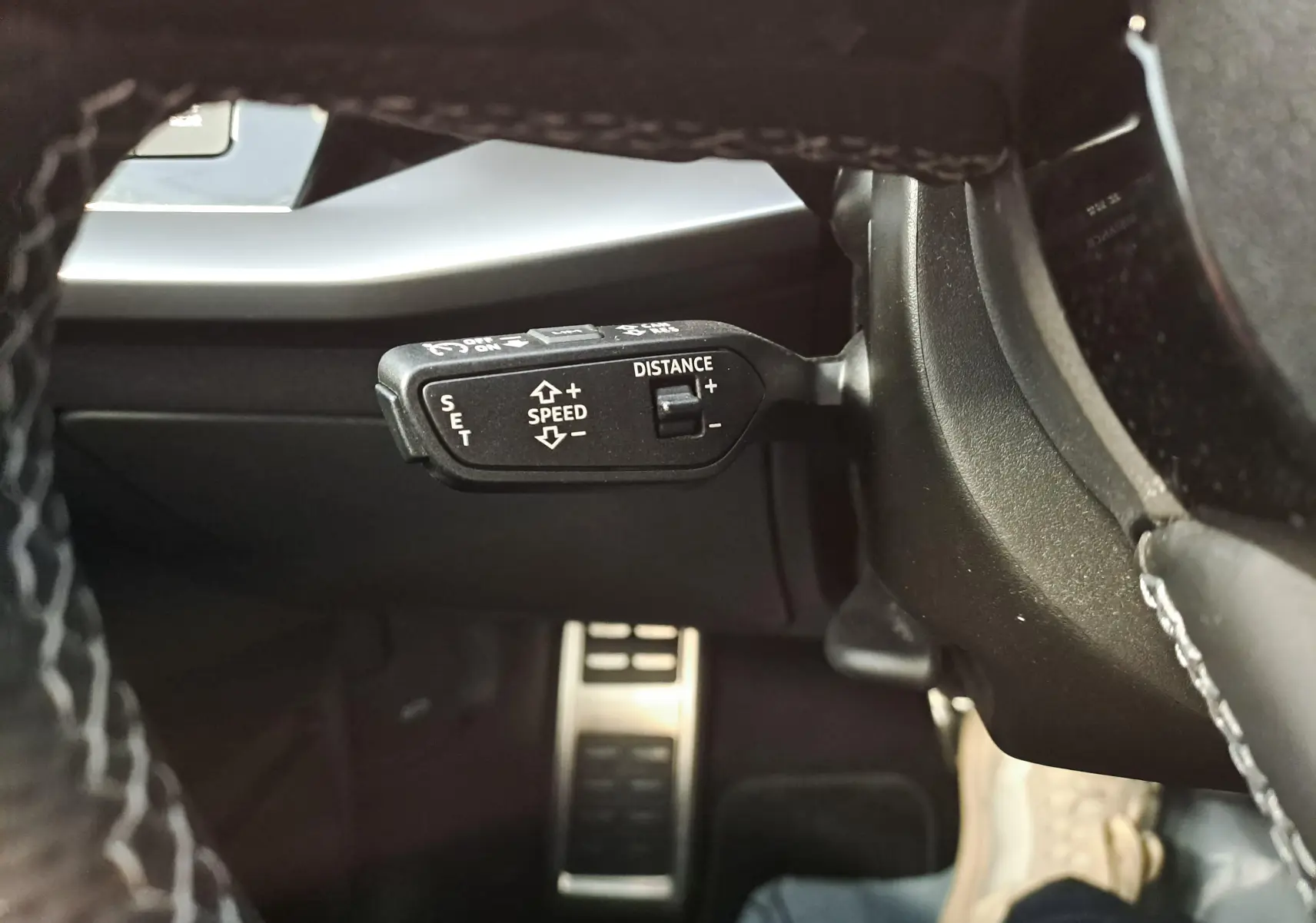 Gros plan sur la commande de régulateur de vitesse à gauche du volant de l'Audi A3 Sportback Noir Mythic 2023.