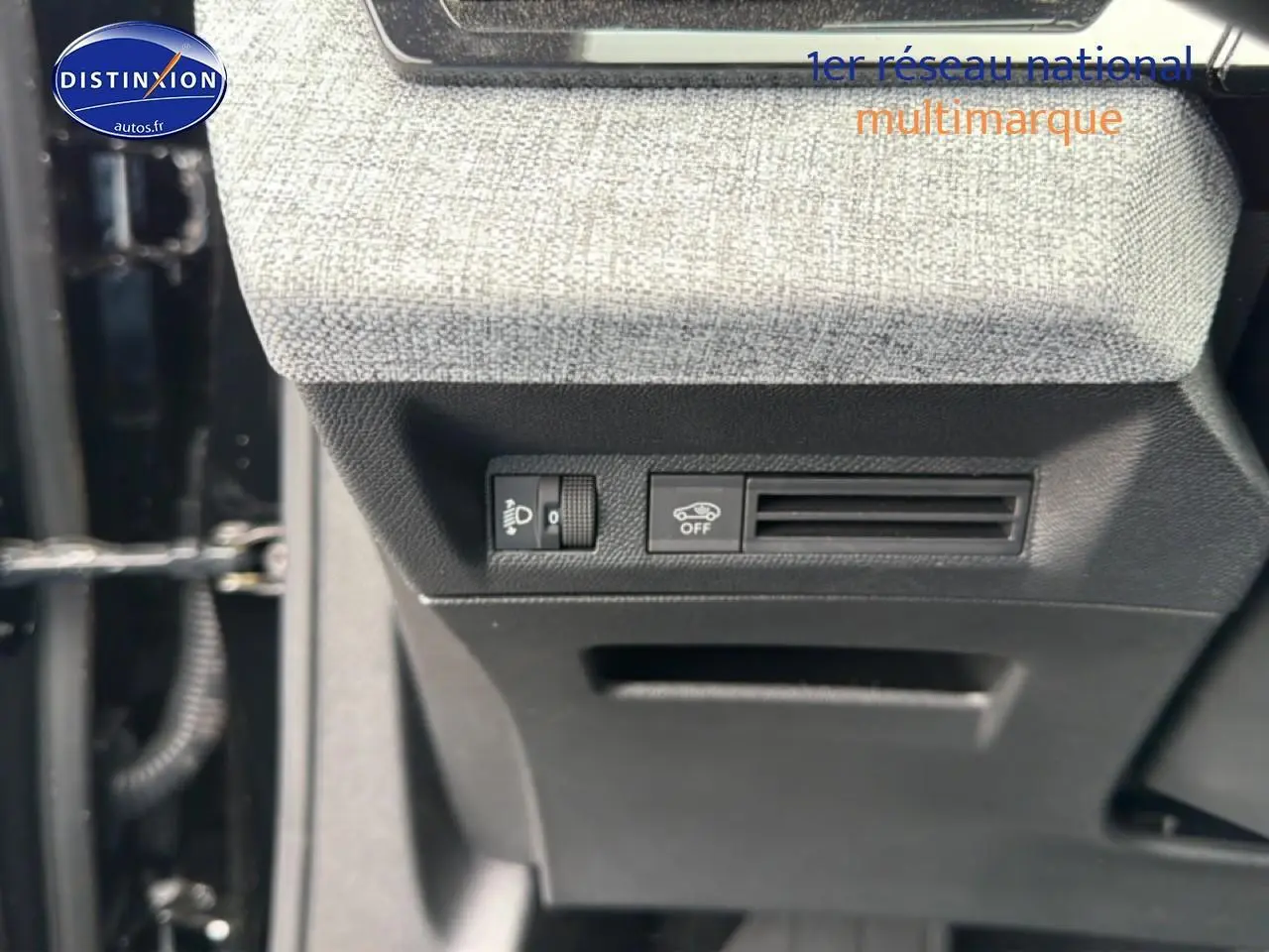 Détail intérieur montrant les commandes sous le tableau de bord avec revêtement tissu gris clair sur Peugeot 5008 noir.