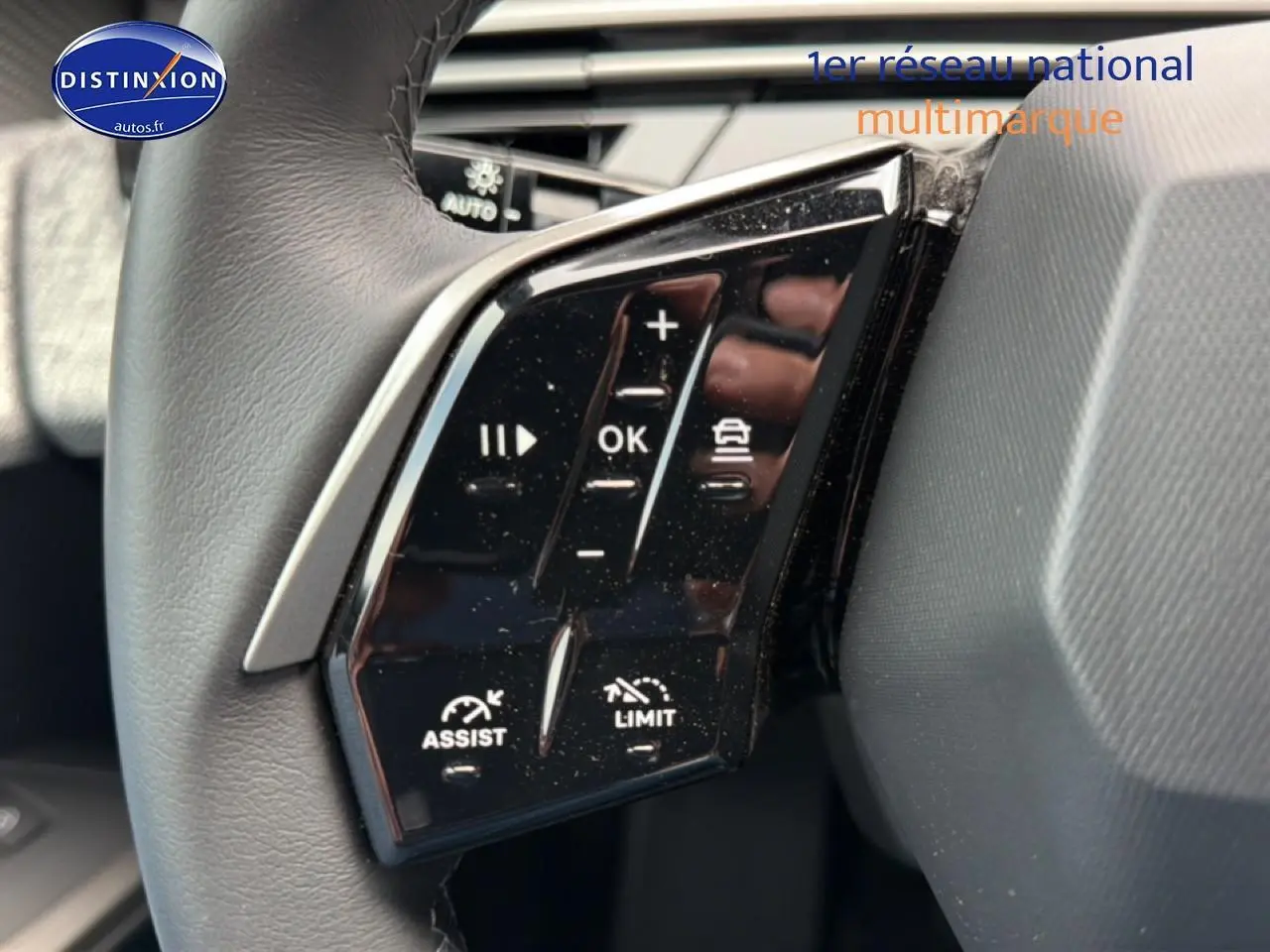 Gros plan sur les commandes au volant noir du Peugeot 5008 Hybrid 145 allure e-dcs6 2025, côté gauche.