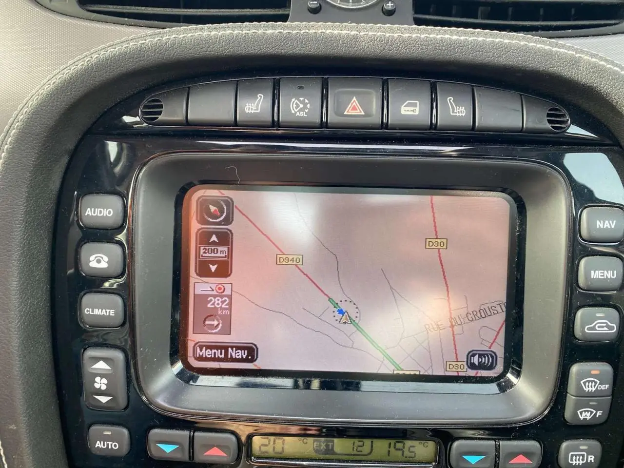 Écran tactile du système de navigation de la Jaguar XJ noire, vue rapprochée du tableau de bord central.
