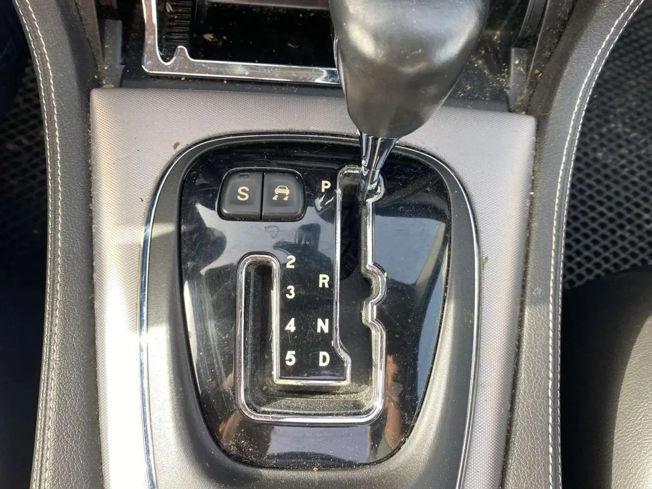 Gros plan sur la console centrale noire de la Jaguar XJ 2006, mettant en valeur le levier de vitesse automatique chromé.