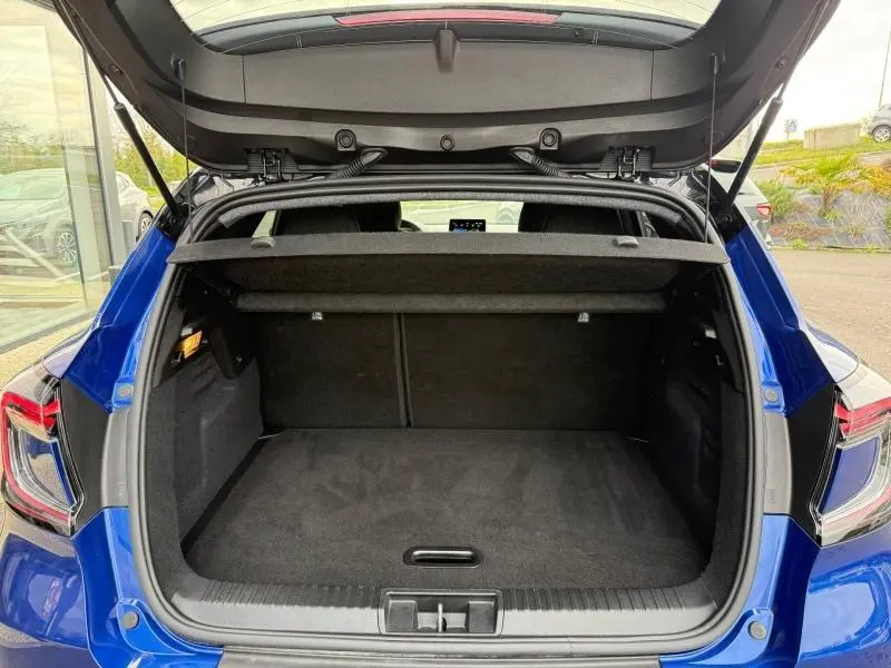 Coffre ouvert vu de l'arrière du Renault Captur 2025 Bleu Iron/Noir Étoilé, montrant l'espace de chargement vide.