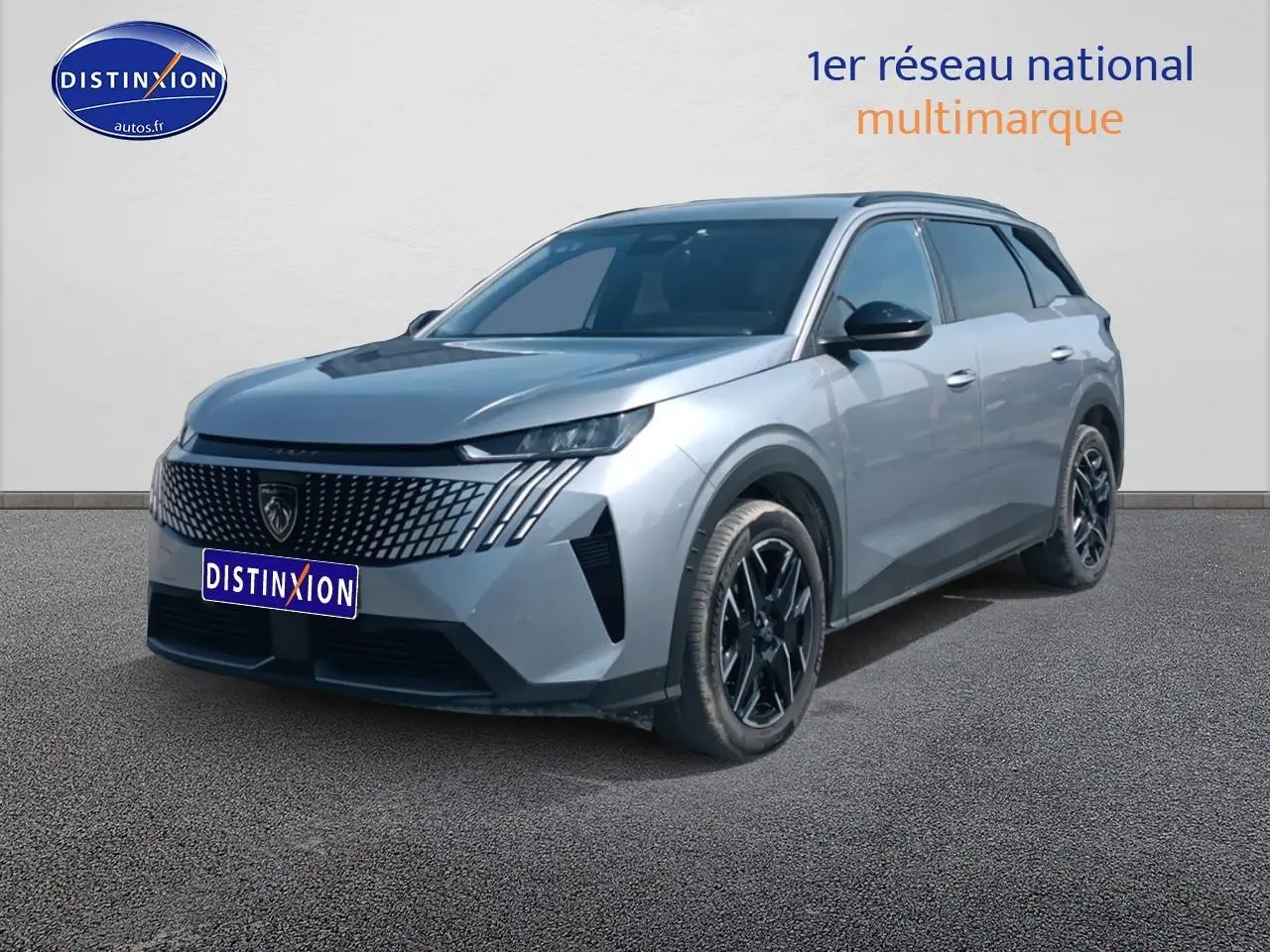 Peugeot 5008 Hybrid 145 gris artense en 3/4 avant droit, avec calandre distinctive et jantes noires.