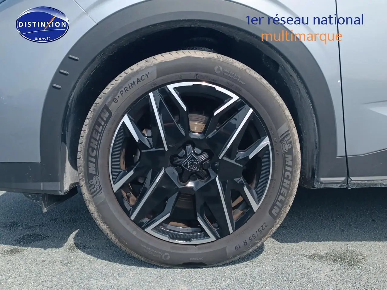 Gros plan sur la roue avant droite du Peugeot 5008 gris artense, mettant en valeur la jante alu noire et argentée.